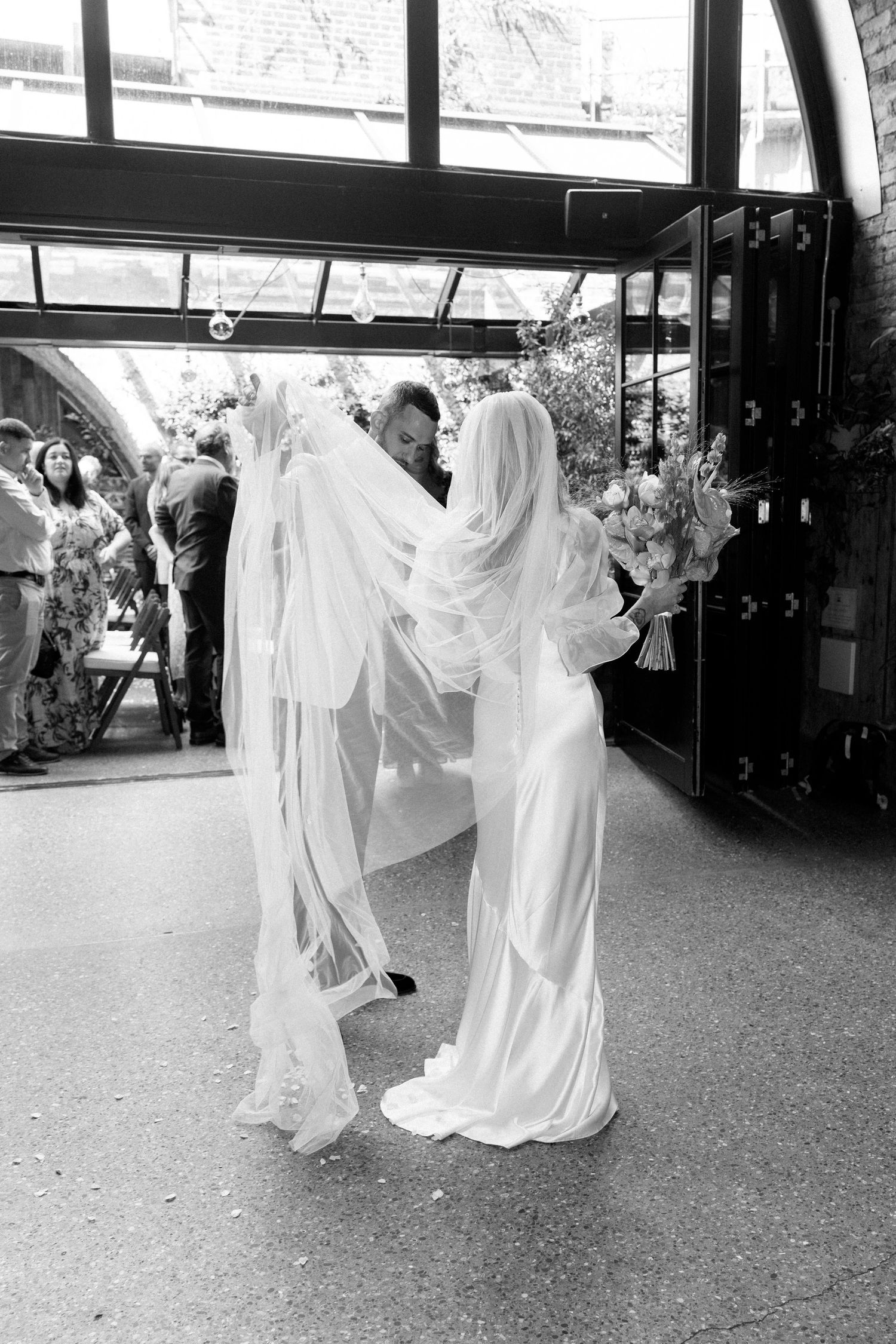 People in flowing white dresses dance and twirl in an indoor space.