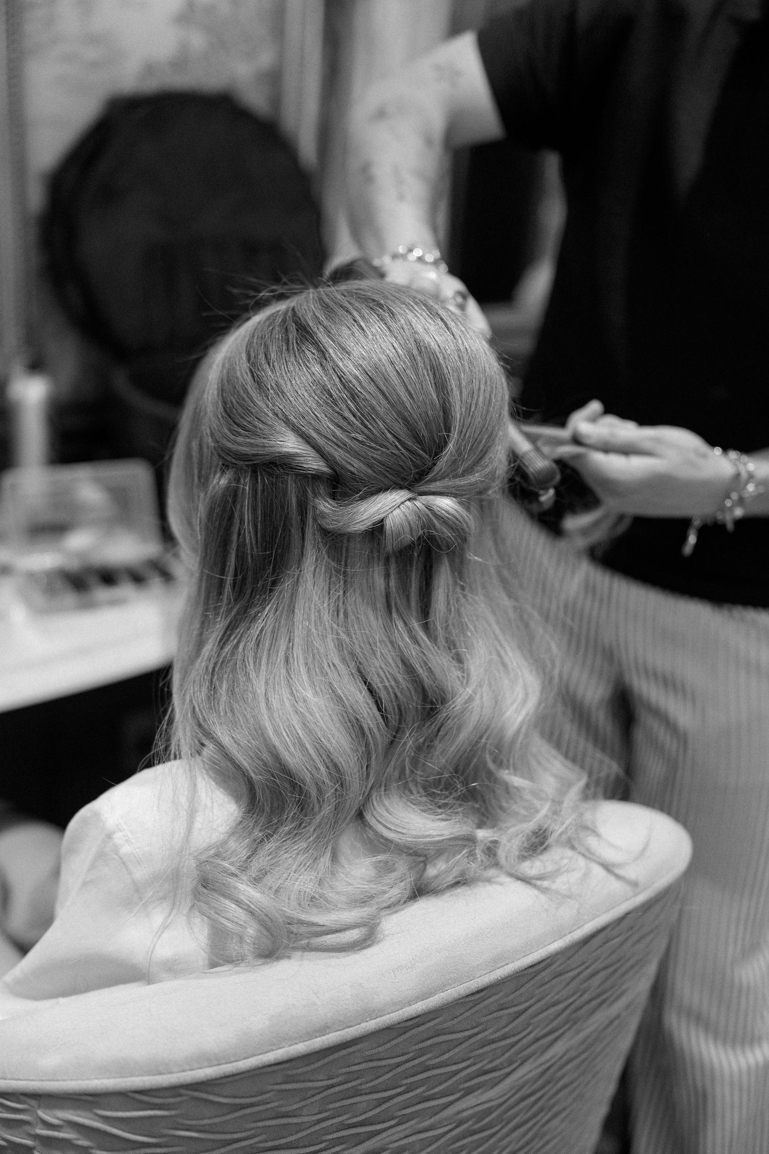Black and white close-up shots of elegant vintage-inspired hairstyling in progress.