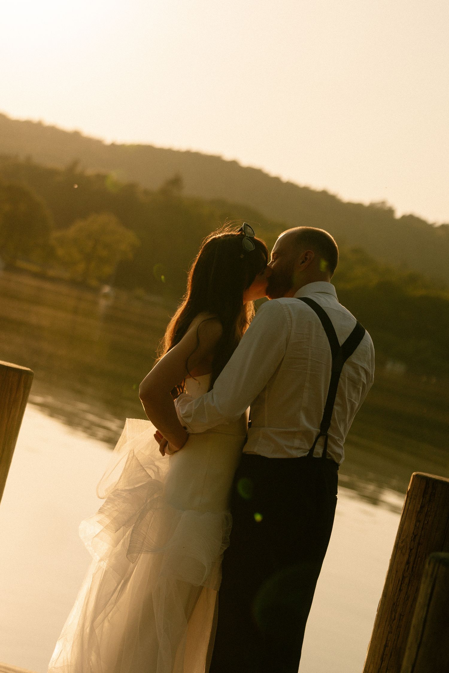 Romantic sunset silhouettes on a lakeside dock.