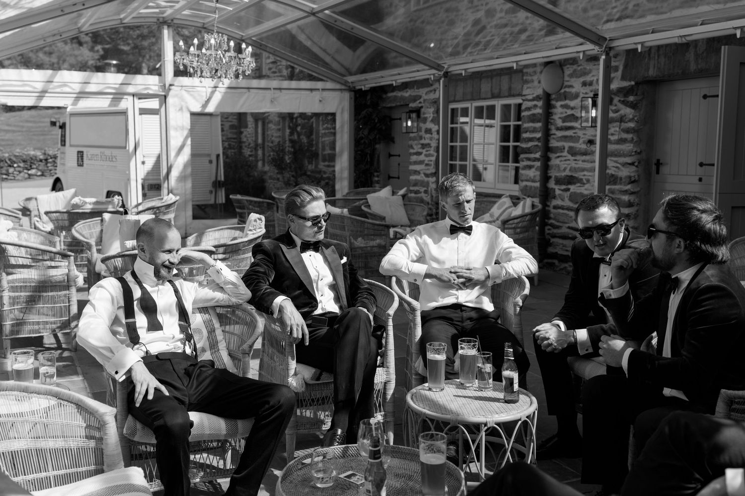Wedding celebration scene with guests seated at outdoor tables.