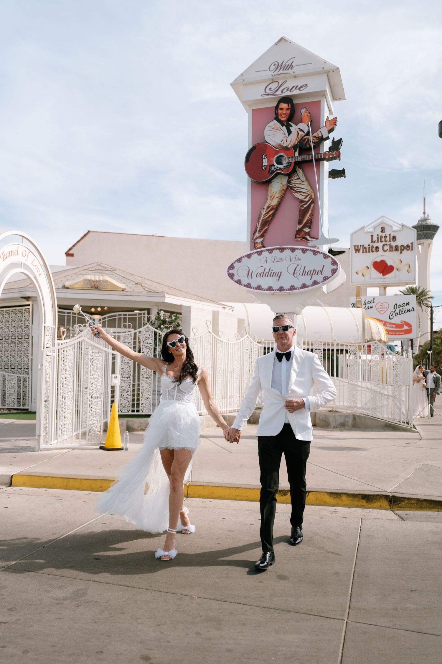 Playful wedding photos taken outside a vintage Las Vegas chapel with retro signage.