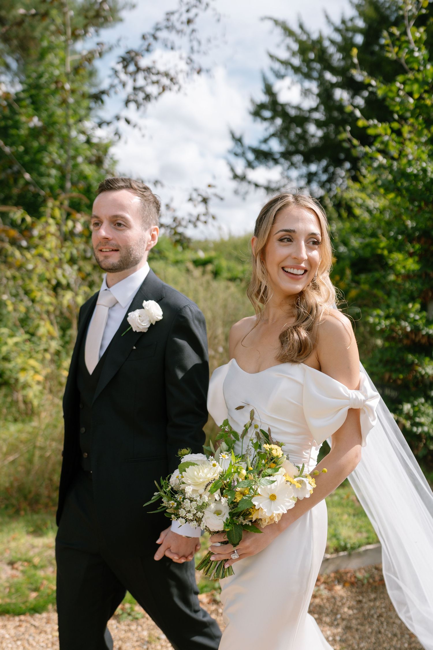 Candid wedding photos showing couple laughing together in garden setting.