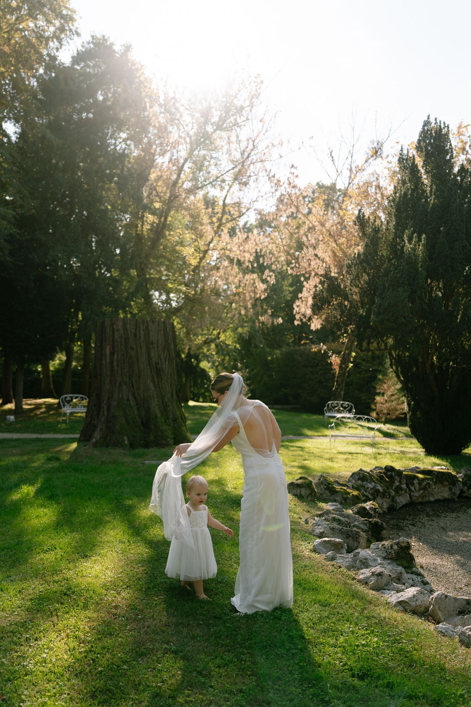 Two figures in white dresses dance in golden evening sunlight.
