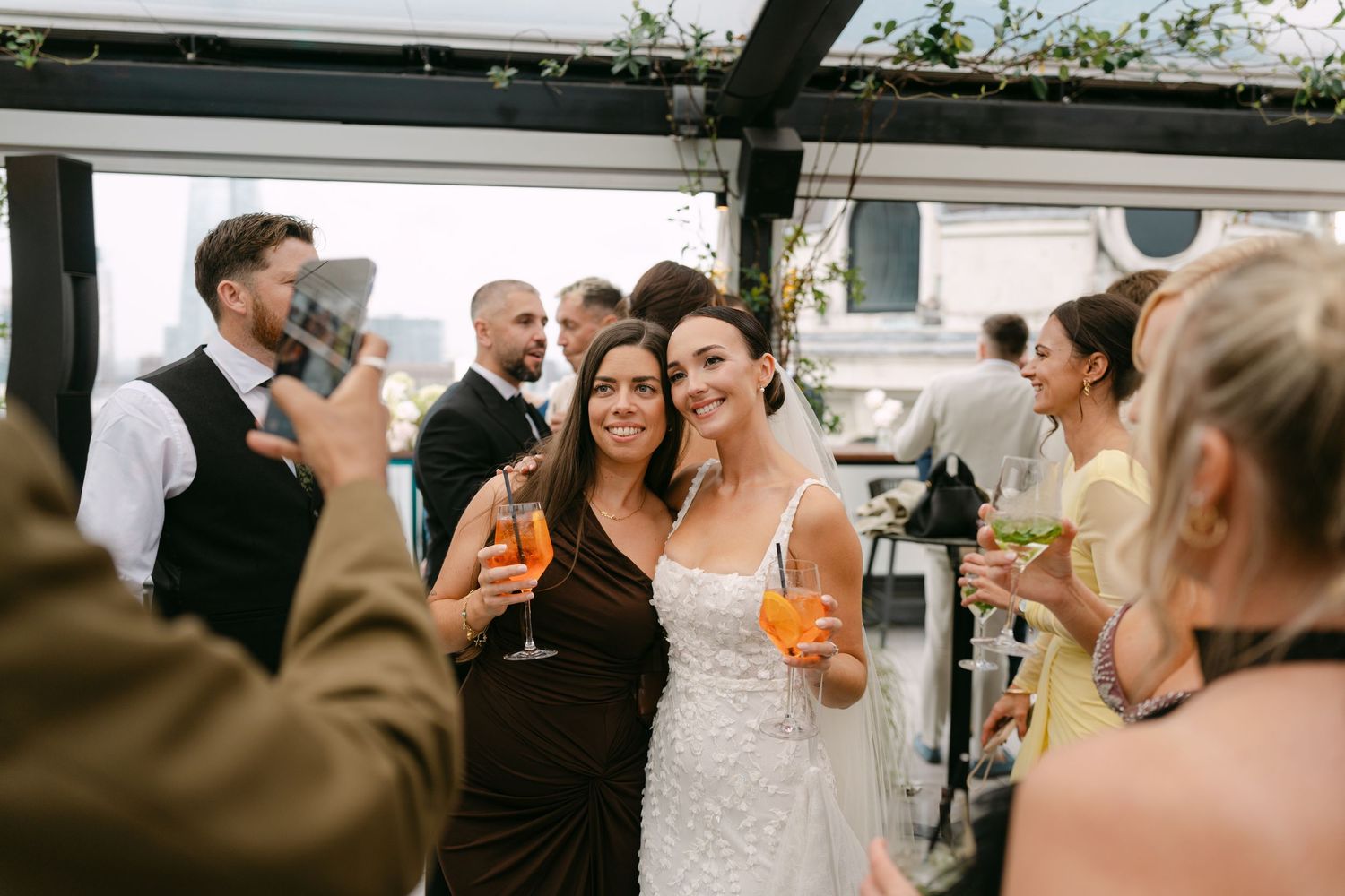 Guests enjoying drinks and conversation at a rooftop wedding reception.