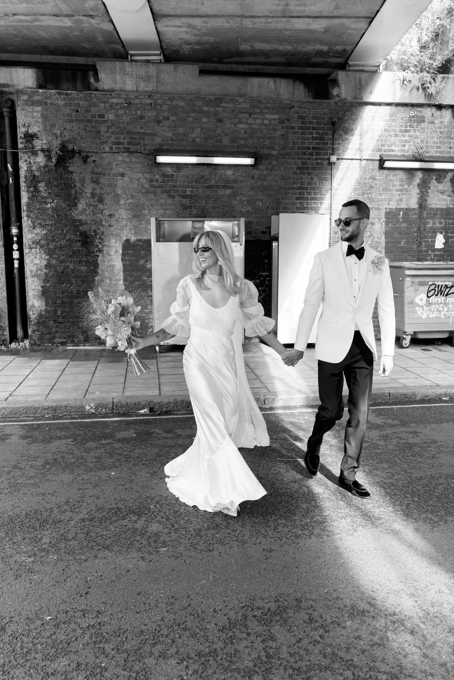 Black and white photo series of wedding couple dancing in an industrial brick venue space.