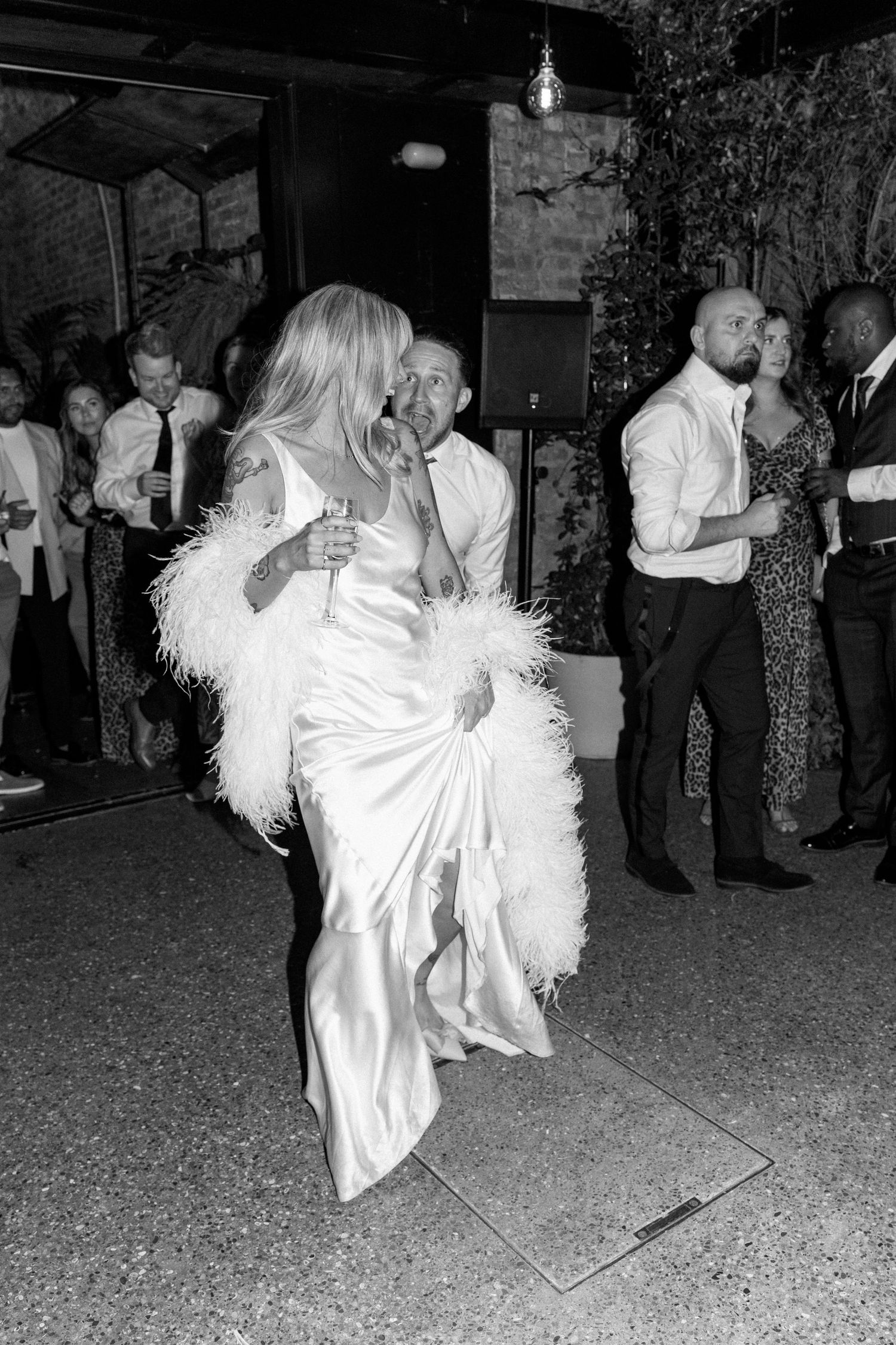 Black and white reception photos showing guests dancing and celebrating on gravel floor.