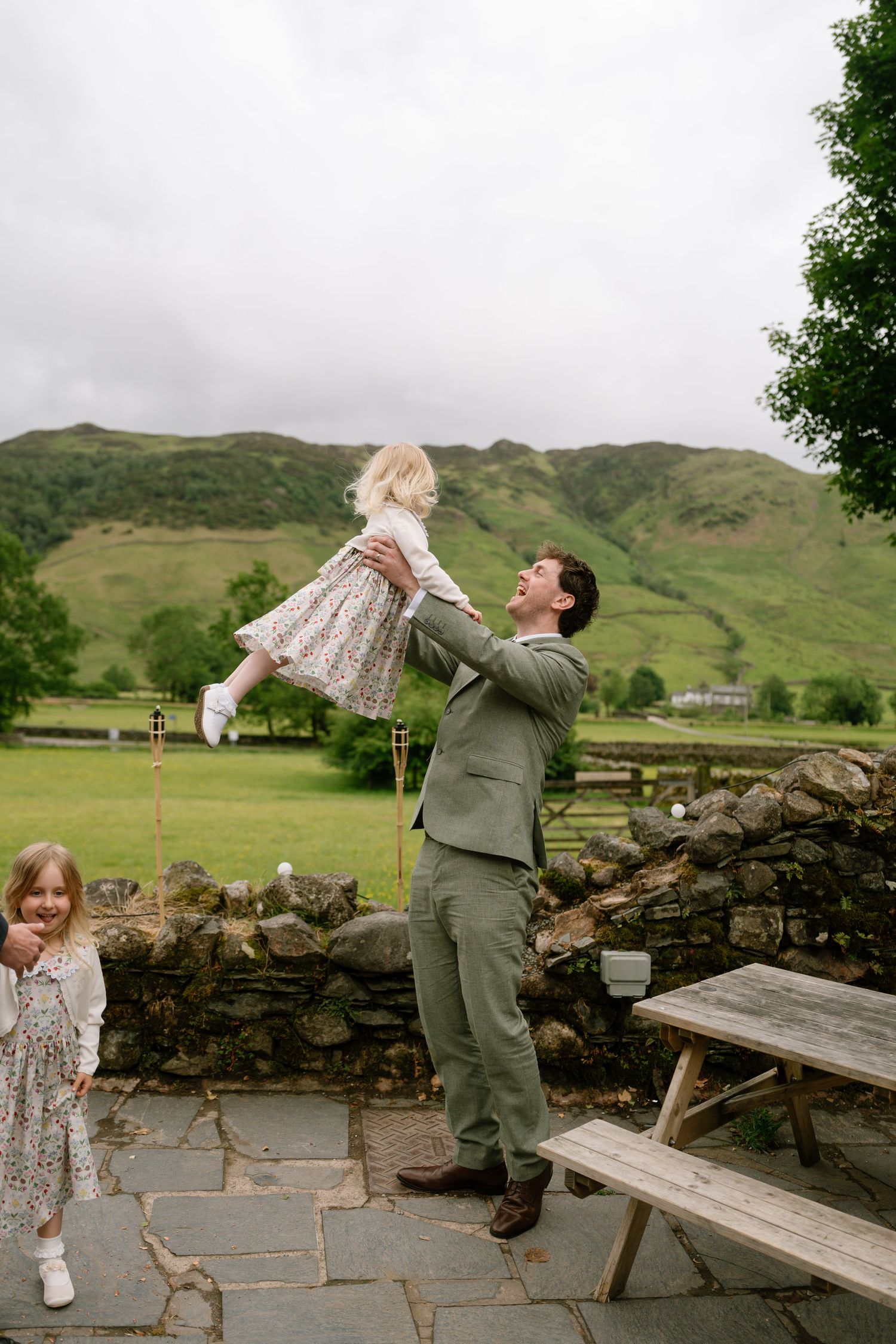 Playful couple dancing and dipping on a stone patio with mountains in background.