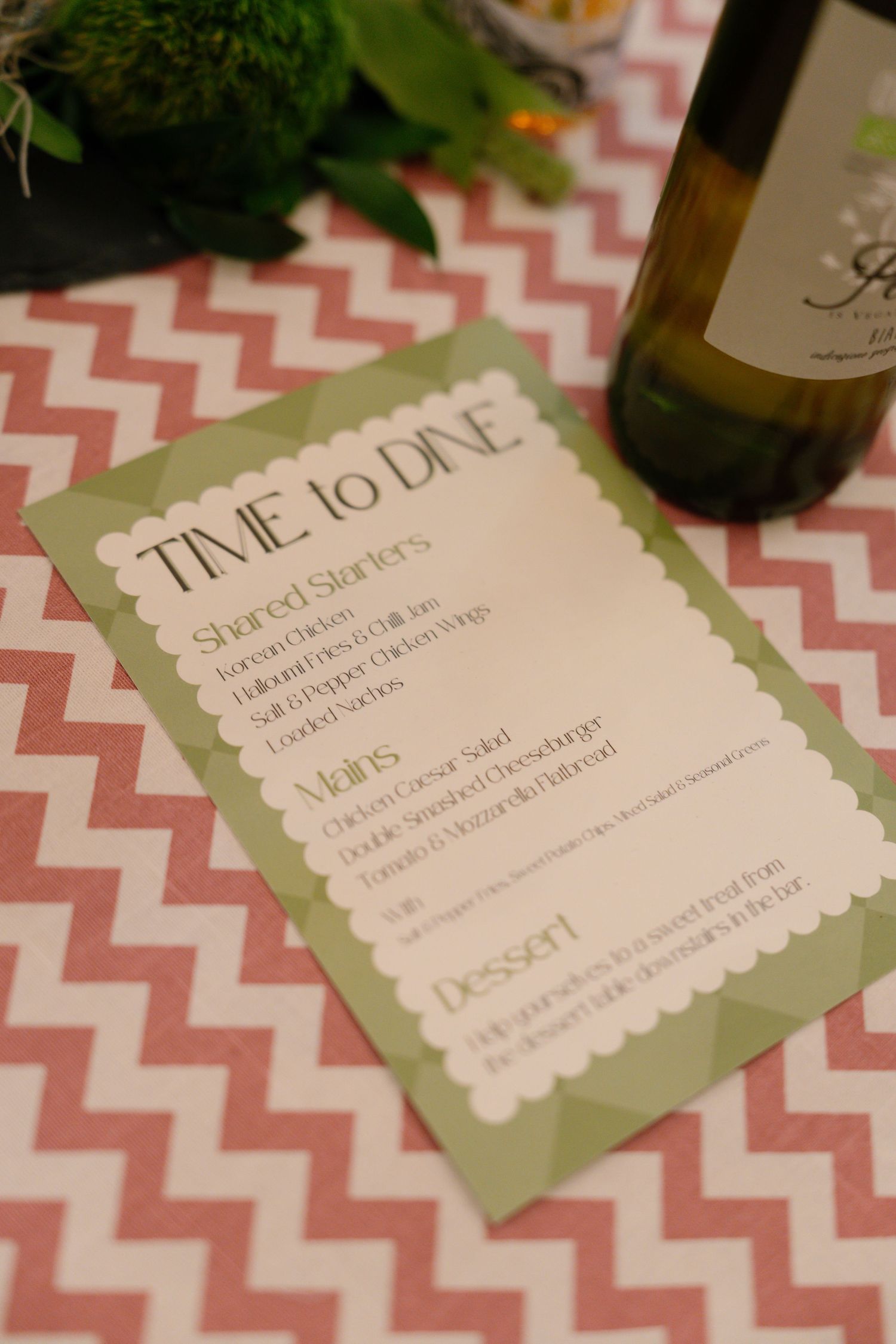 Wedding menu cards with pink chevron pattern and green borders on display.