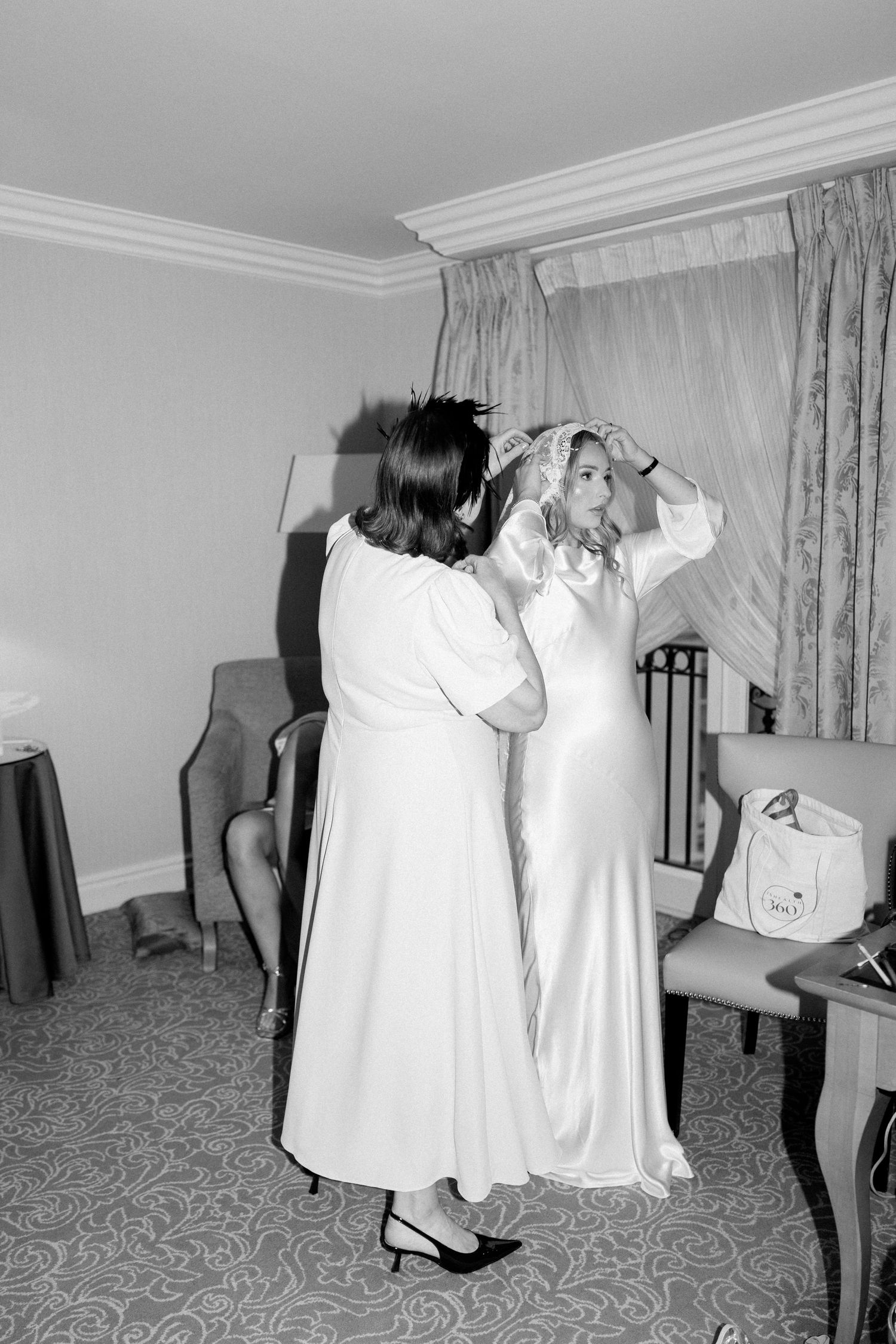 Series of dress fitting moments captured in black and white showing white gowns in a carpeted room.