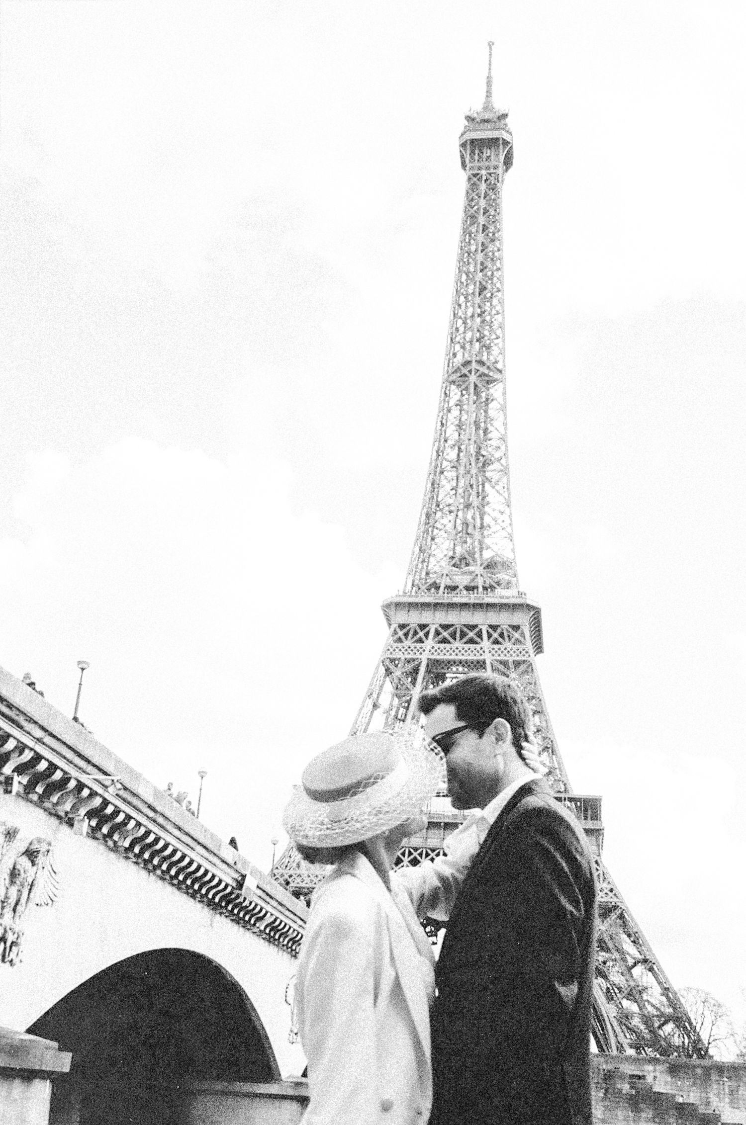 A couple poses romantically in front of the Eiffel Tower in Paris across multiple black and white photographs.
