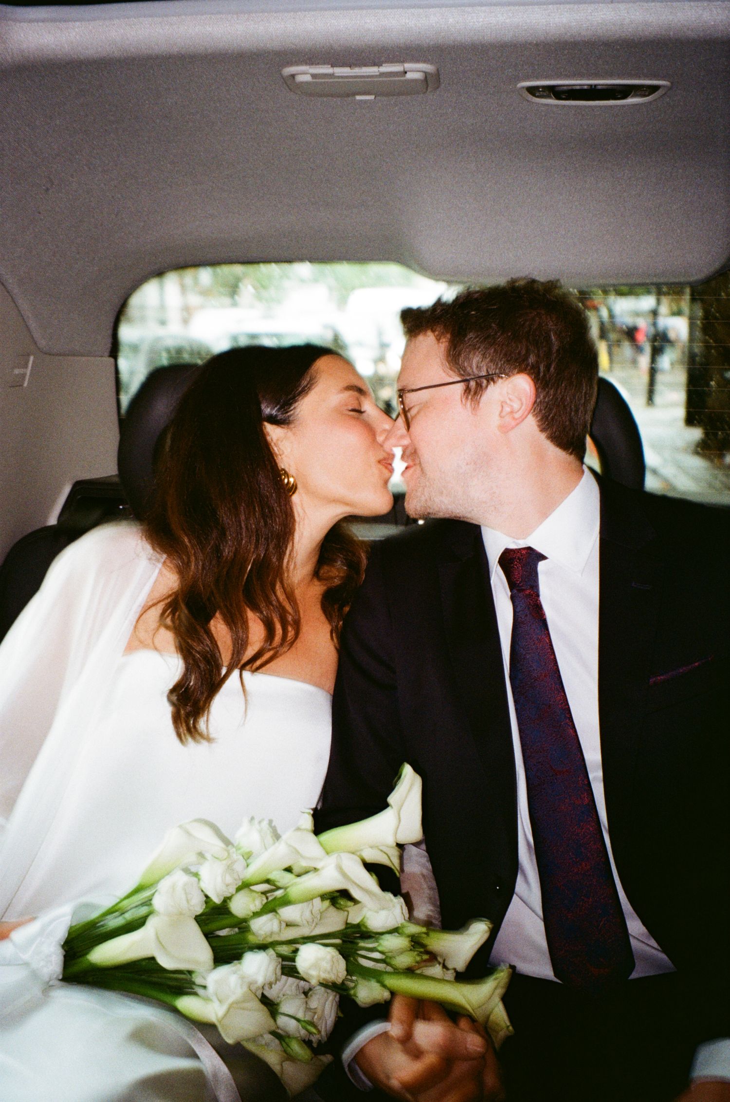 A romantic sequence of wedding photos showing tender moments between newlyweds in the back of a car.