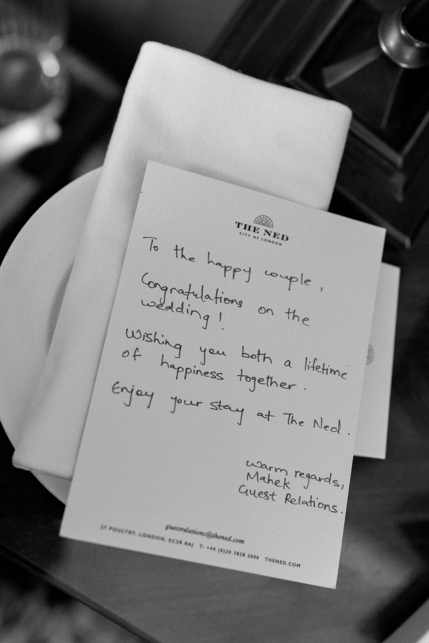 Handwritten wedding congratulations card from The Ned London hotel guest relations on white stationery.