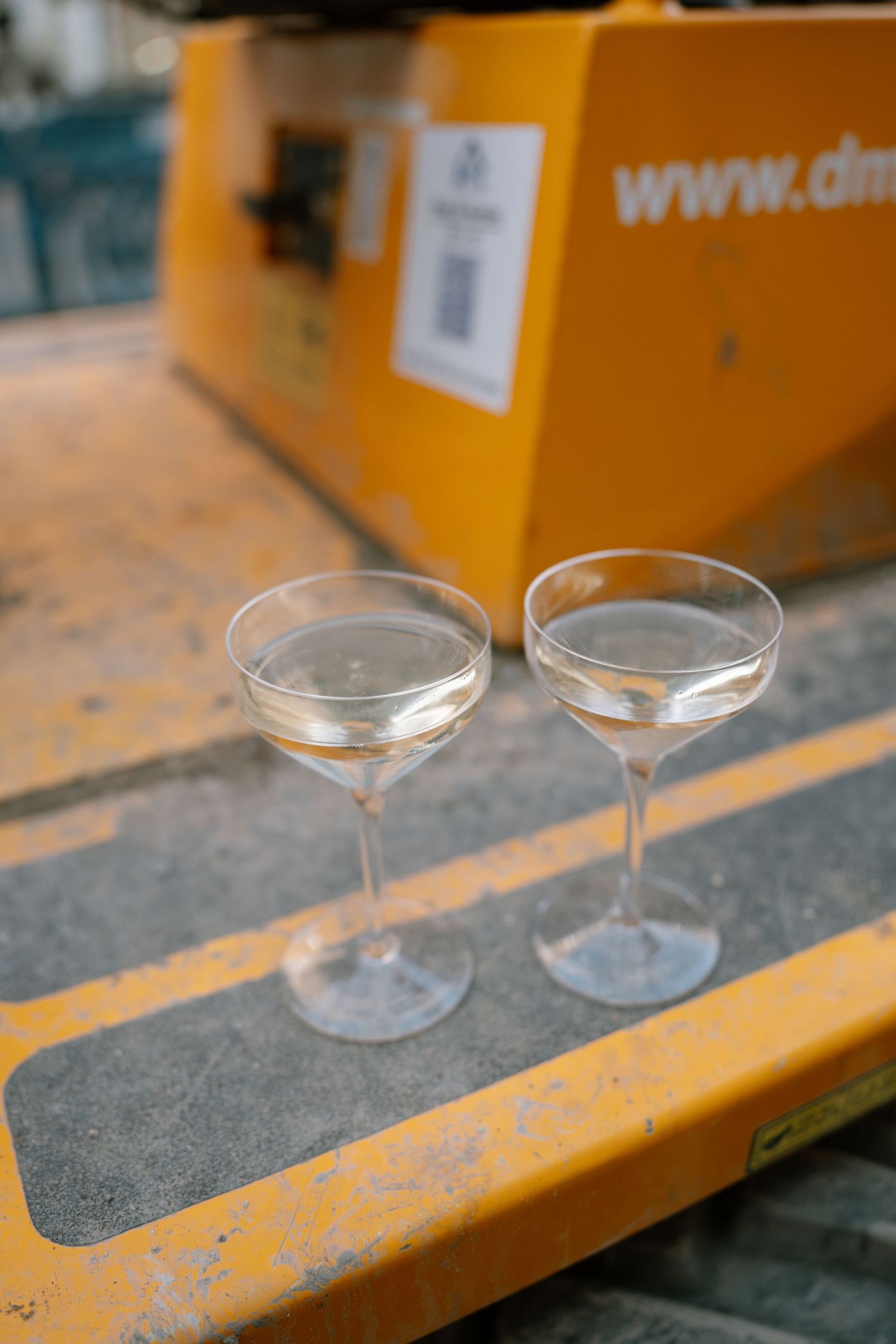 Empty martini glasses lined up on a yellow surface.