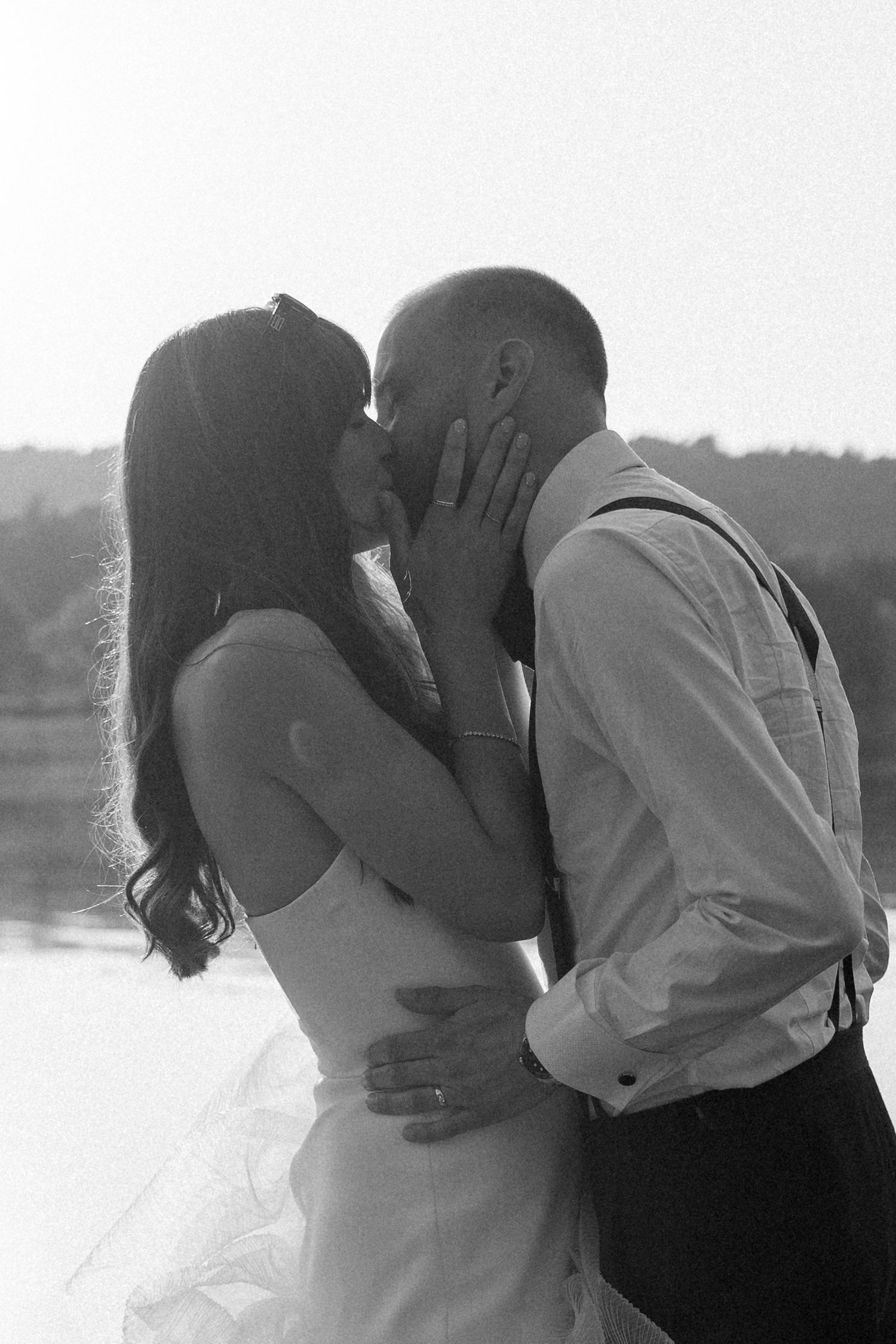 Romantic black and white photo sequence of a couple kissing against a snowy winter backdrop.