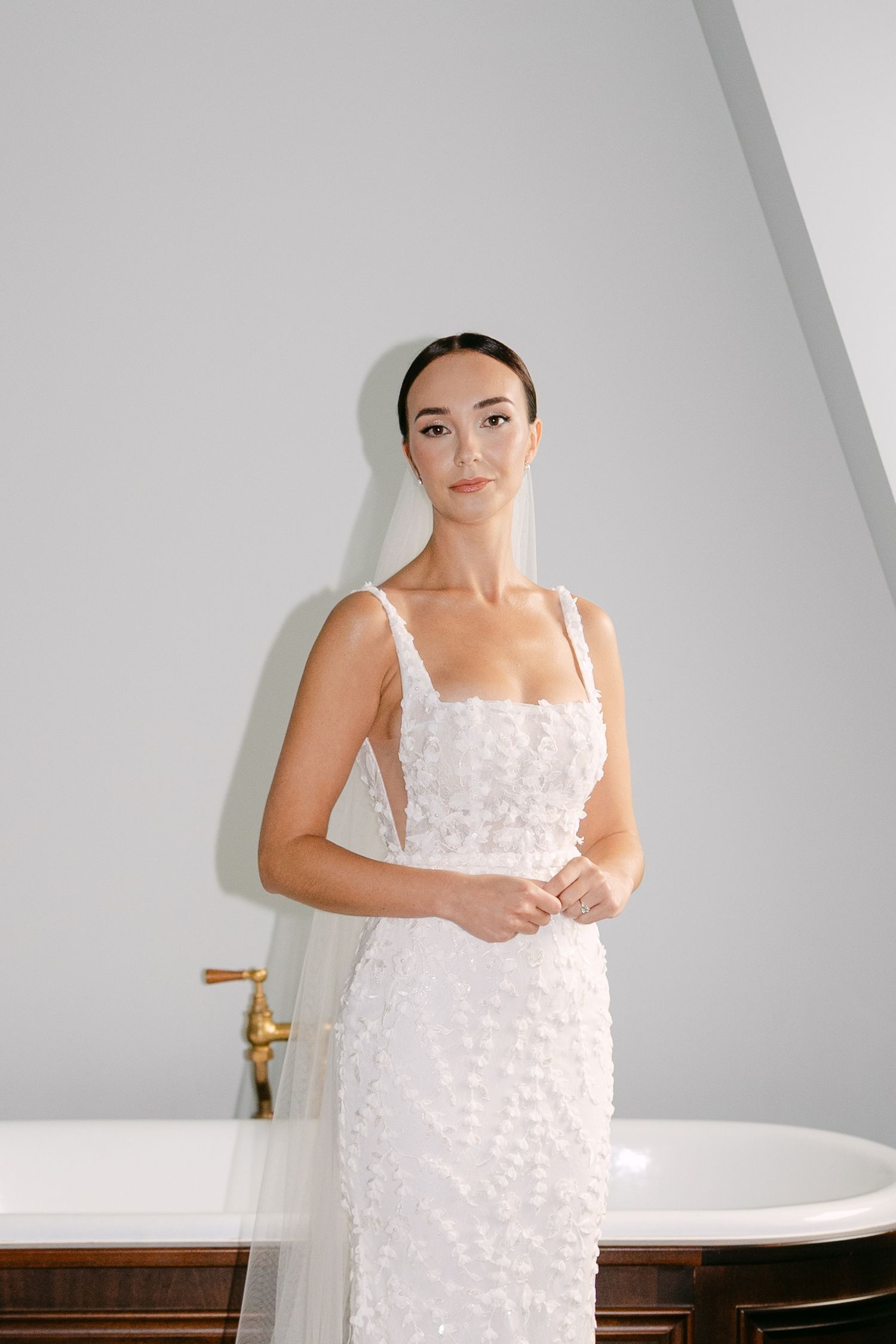 Minimalist bridal portraits against white walls featuring textured wedding gown.