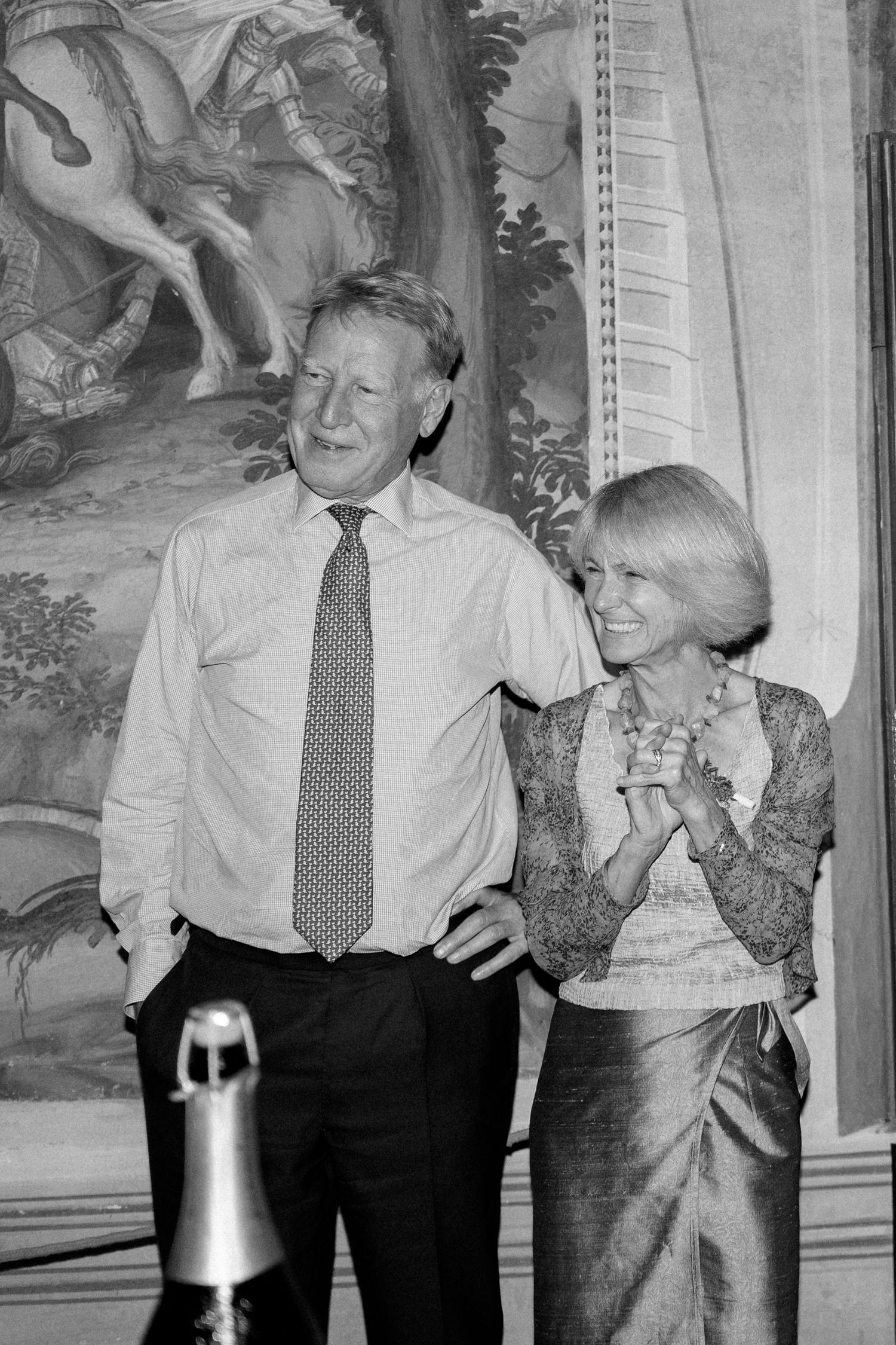 People laughing and celebrating at a formal event in black and white.