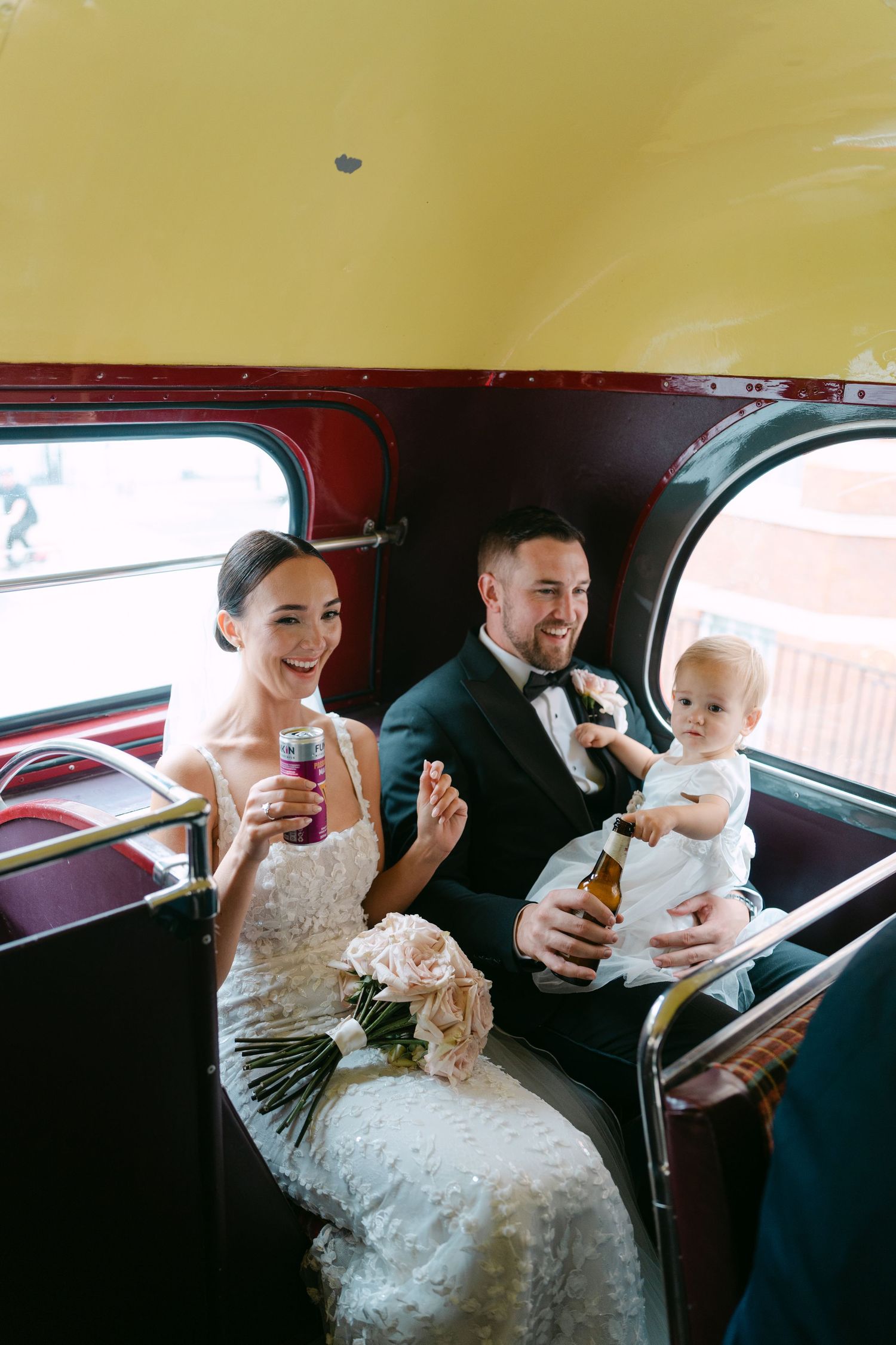 Candid moments shared between wedding couple inside vintage bus interior.