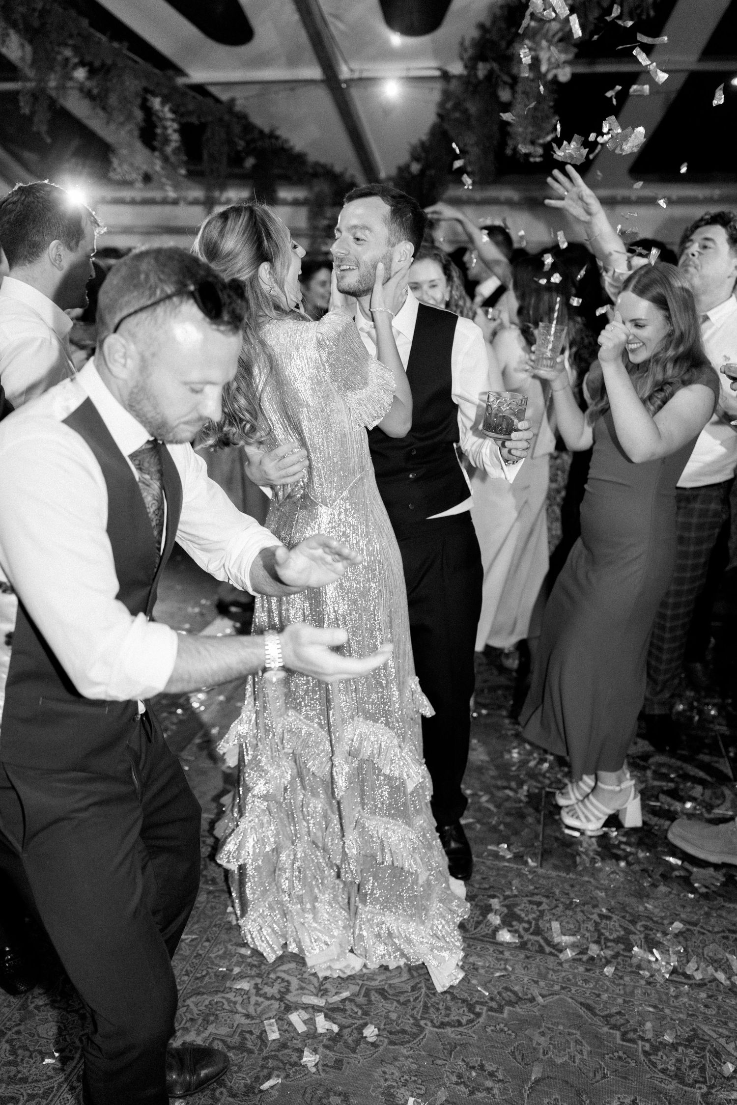 Wedding reception dance floor filled with guests celebrating in black and white.