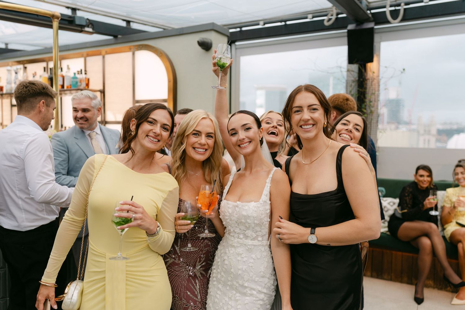 Wedding celebration with guests mingling and laughing at an indoor venue.