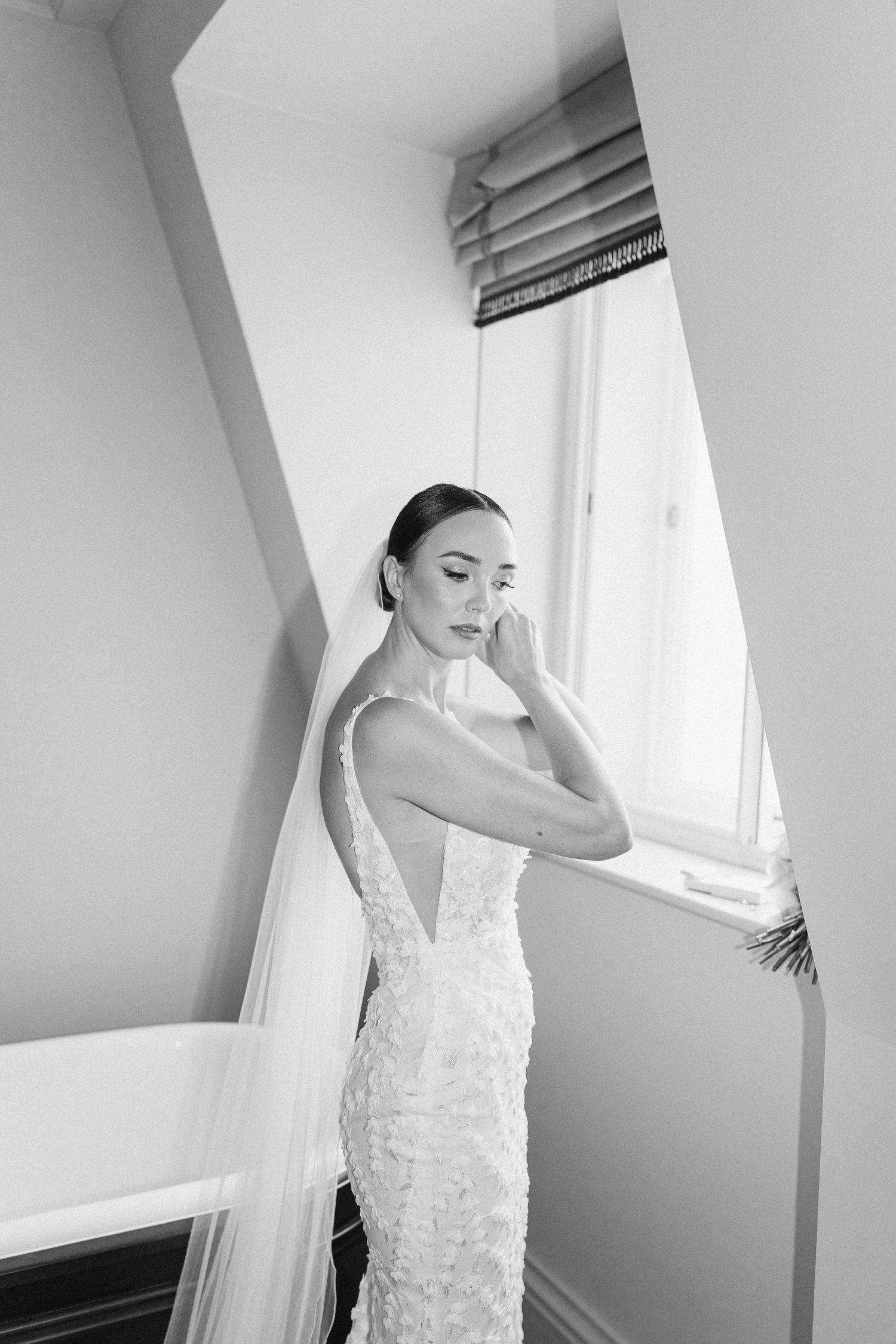 Ethereal bridal portraits showing flowing white dress against bright window light.