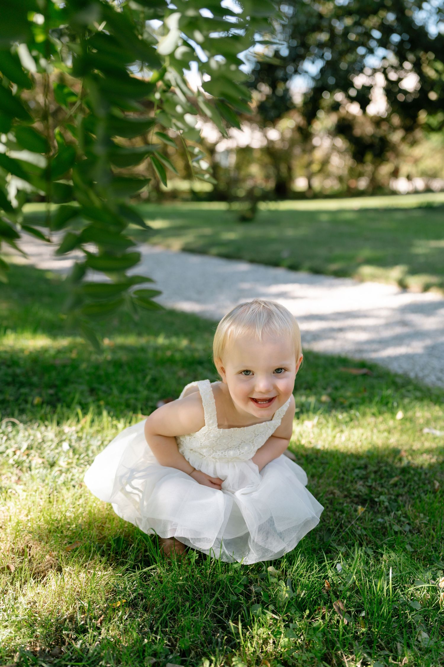Candid sequence of someone in white lying on sunny garden grass.