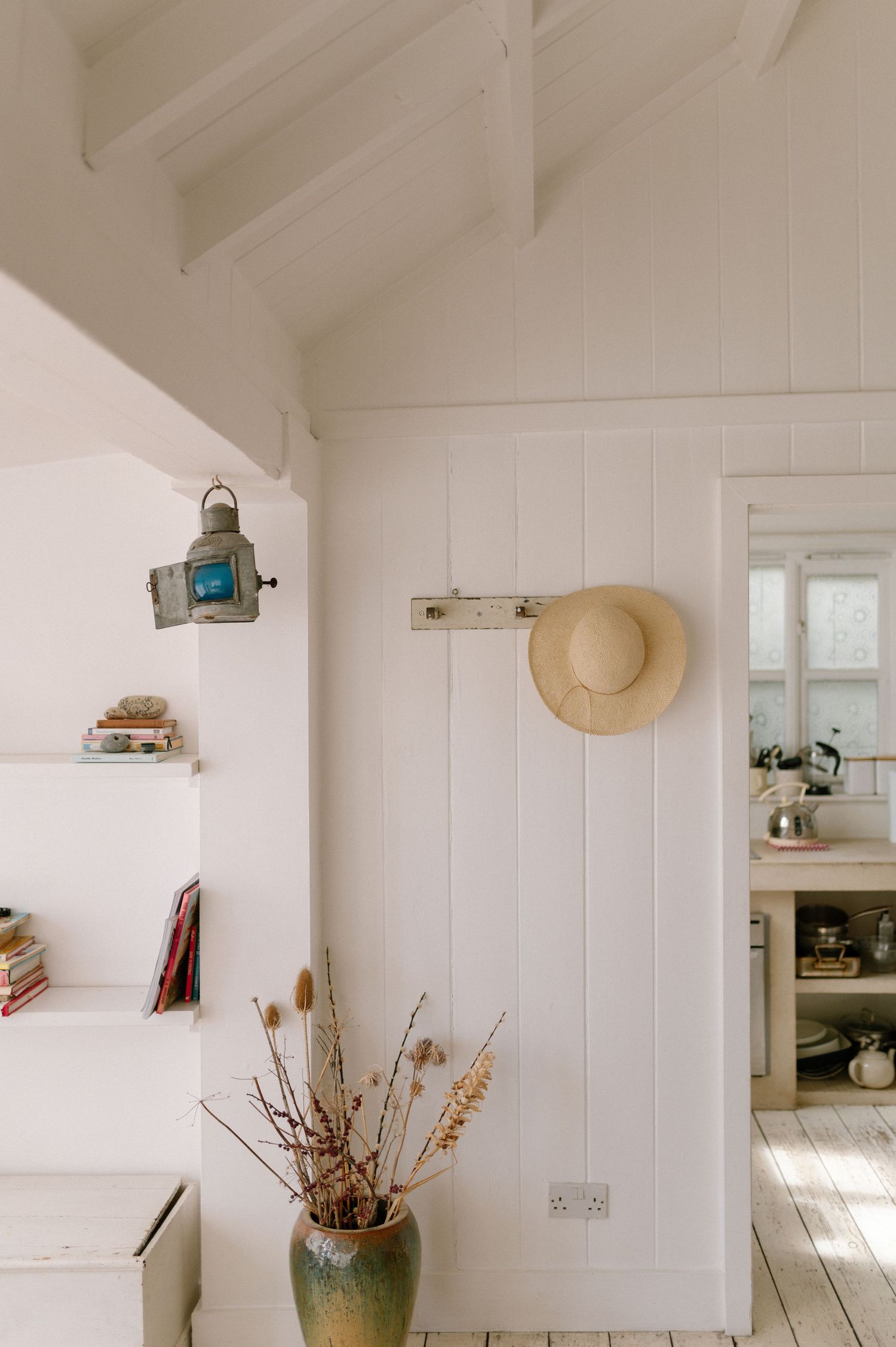 Minimalist white interior with vertical paneling and scattered decor items.