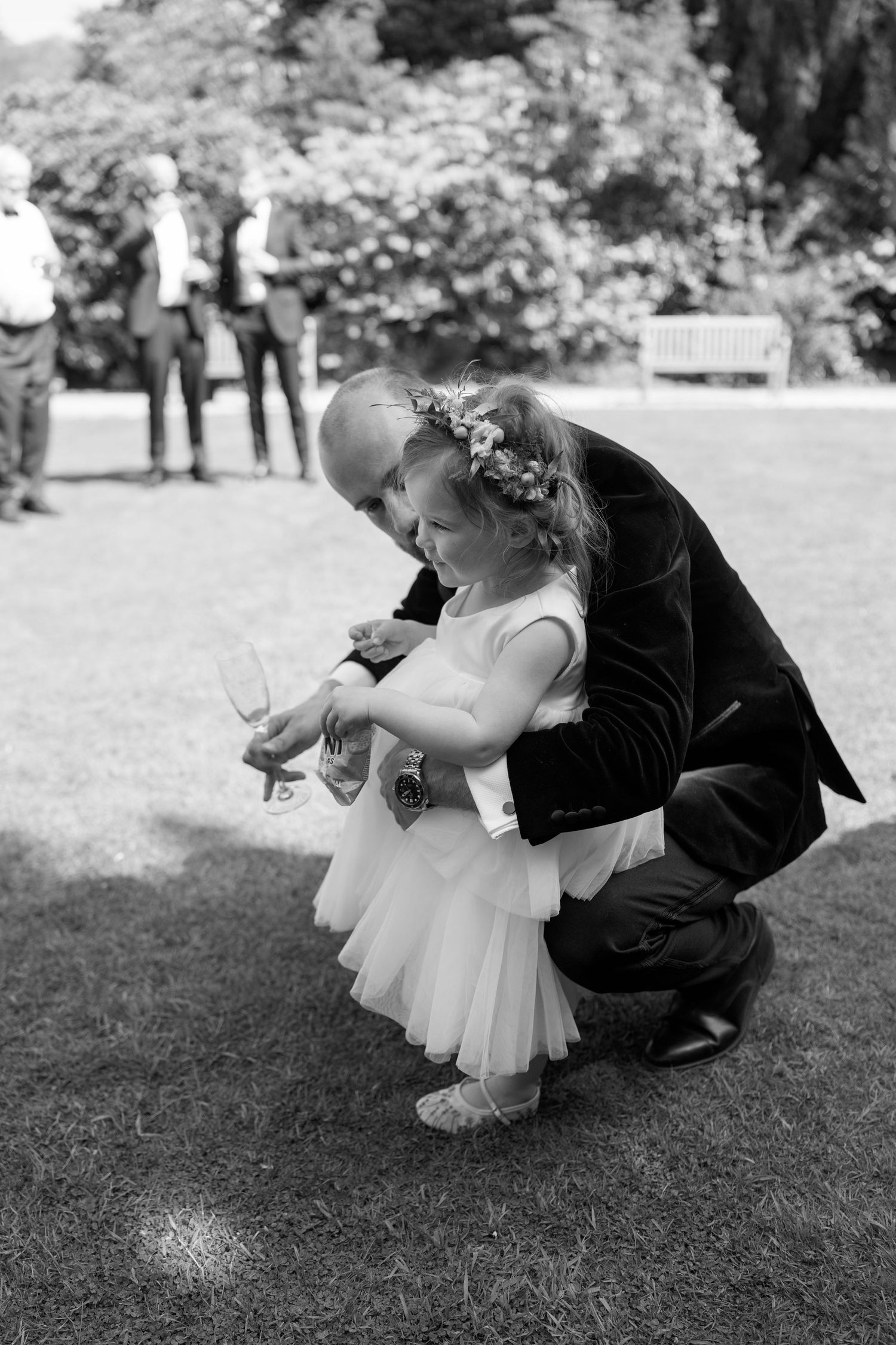 A tender moment between an adult and small child in formal attire at a wedding.