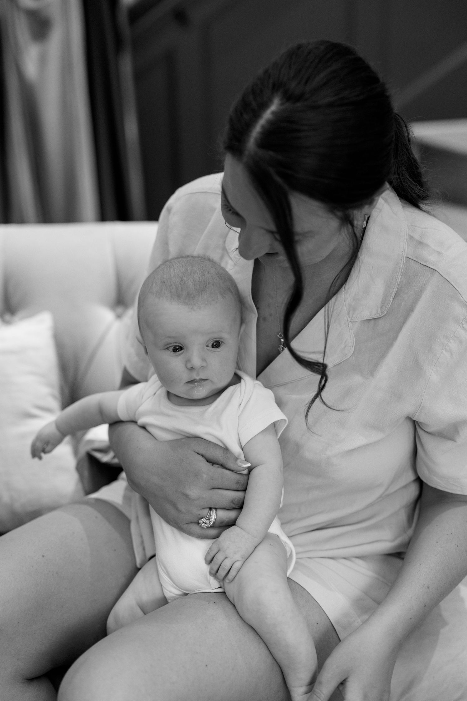 Tender moment captured in black and white on a white sofa.