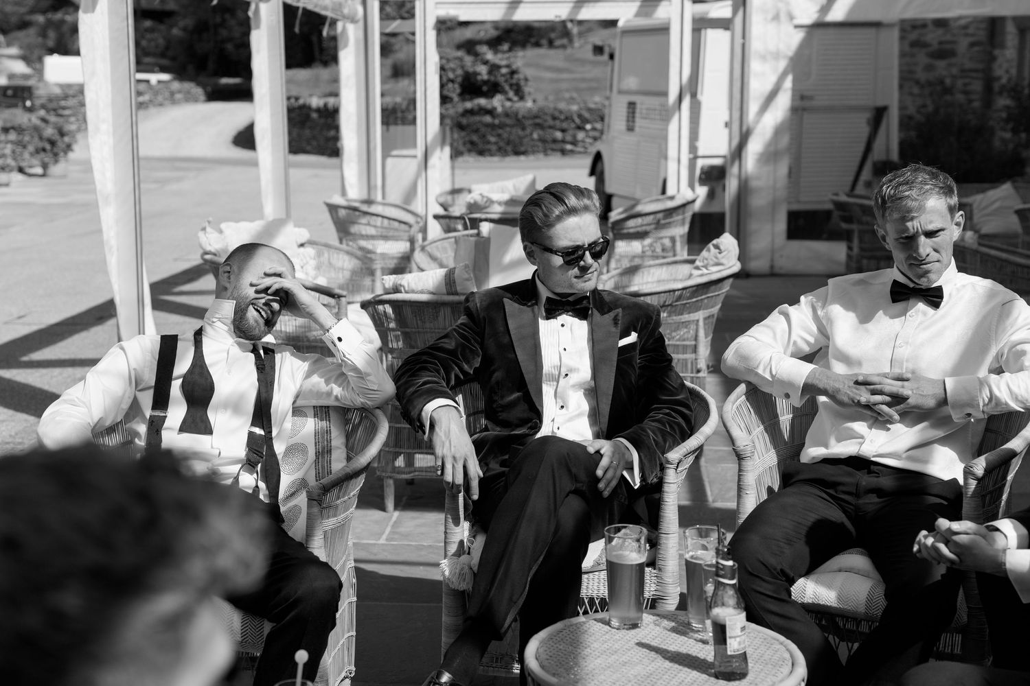Black and white photo of wedding guests socializing at outdoor tables.