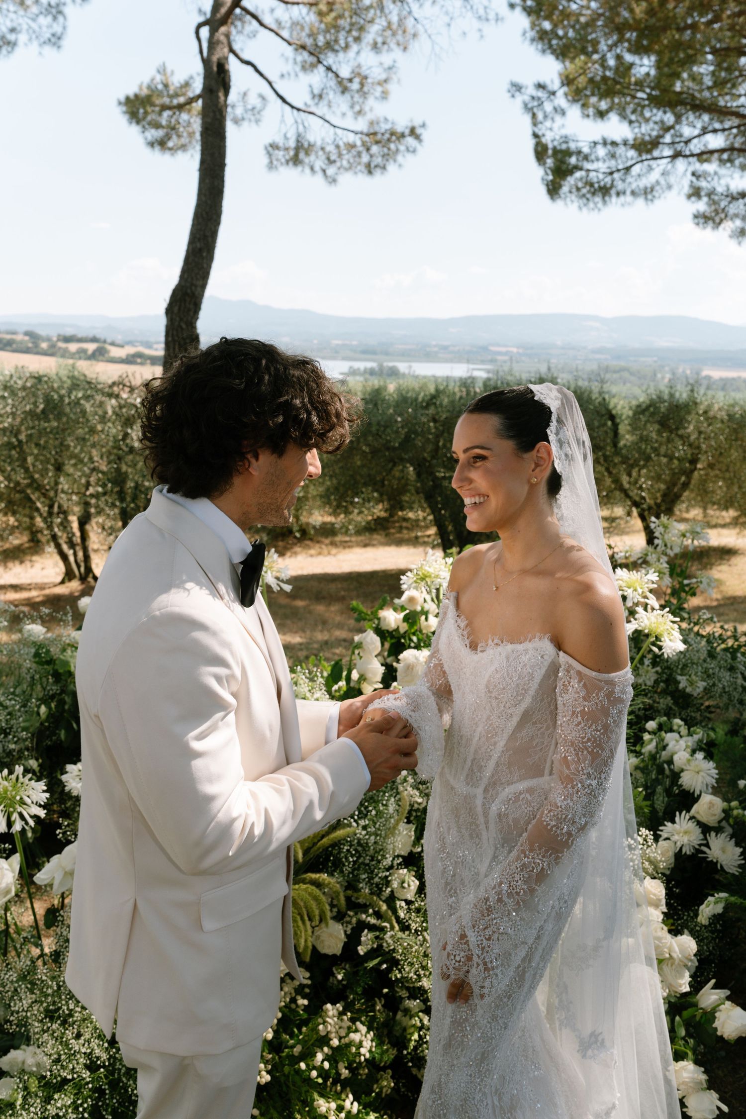 A couple sharing a romantic moment in an olive grove during their wedding day.