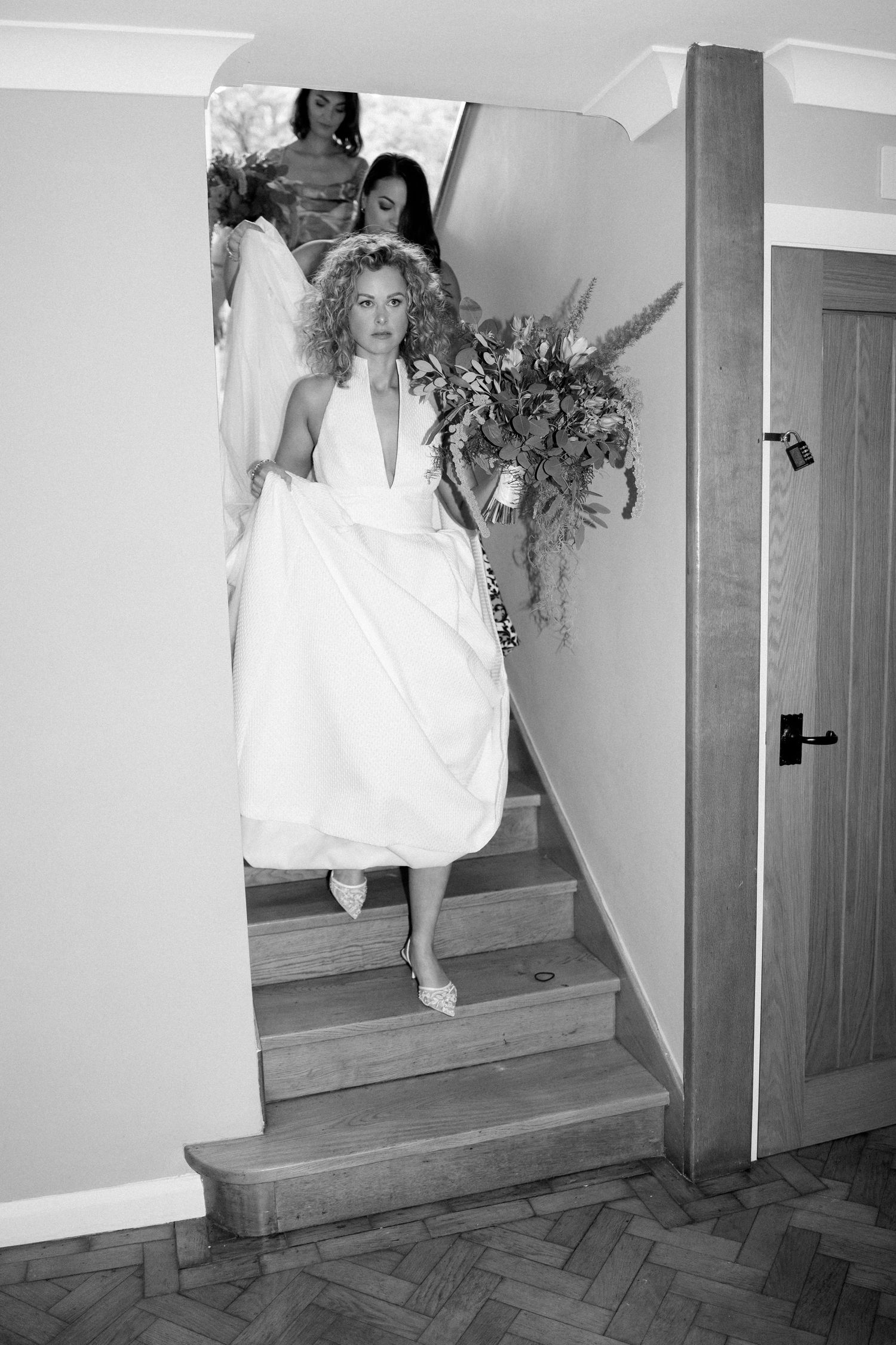 A series of black and white photos showing a bride descending stairs with flowing white dress.