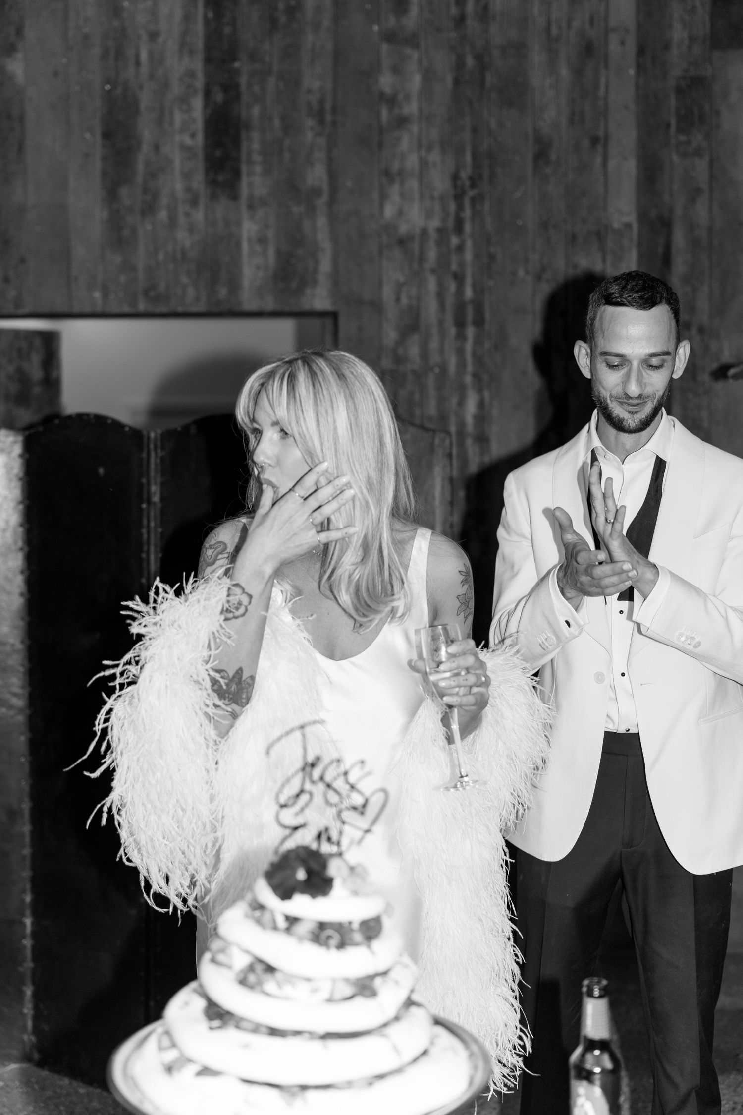 Black and white photo of a couple sharing an intimate moment at their wedding reception.