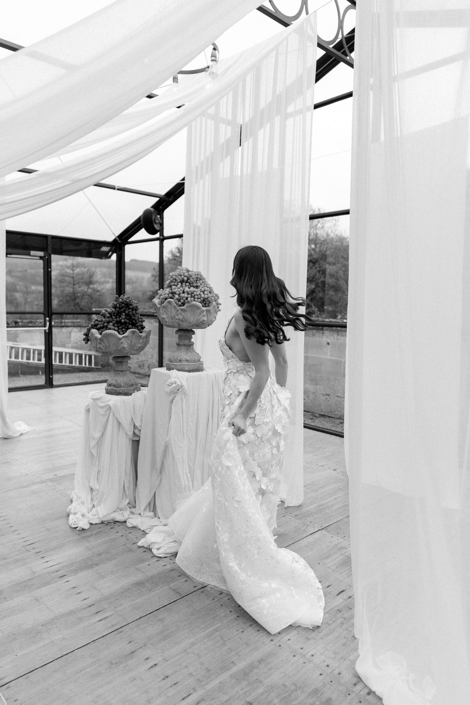 Ethereal wedding scene with flowing white drapes and wooden deck backdrop.