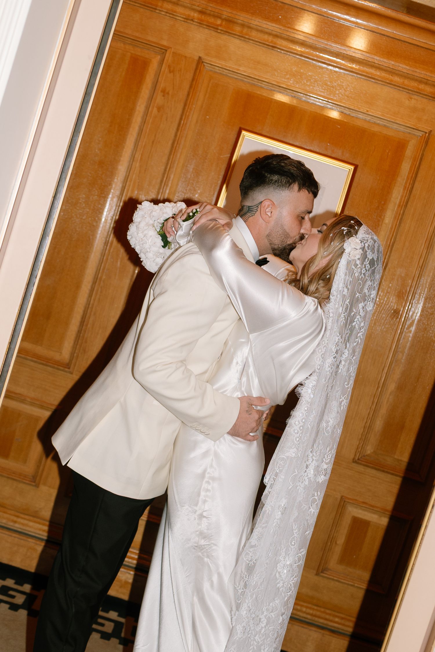 Wedding preparations in a wood-paneled room with formal attire.