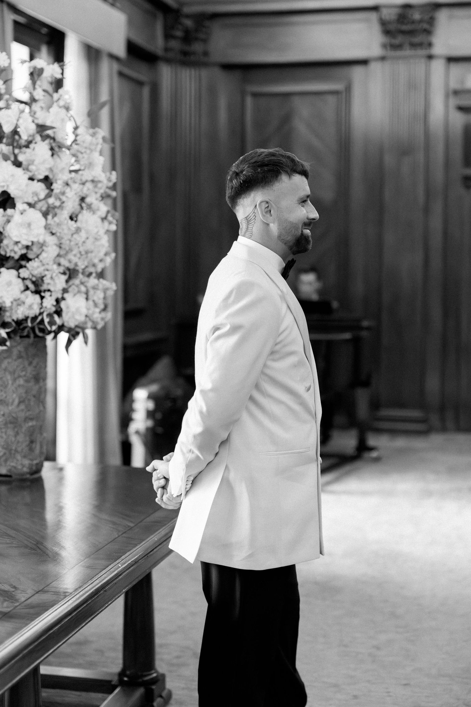 A sequence of black and white photos showing a person in formal attire walking through an elegant venue with floral decor.