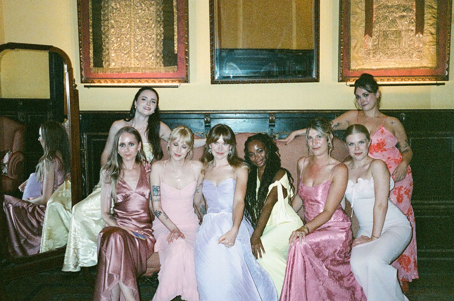 A collage of wedding party photos showing bridesmaids in pink and white dresses posing together at a formal event.