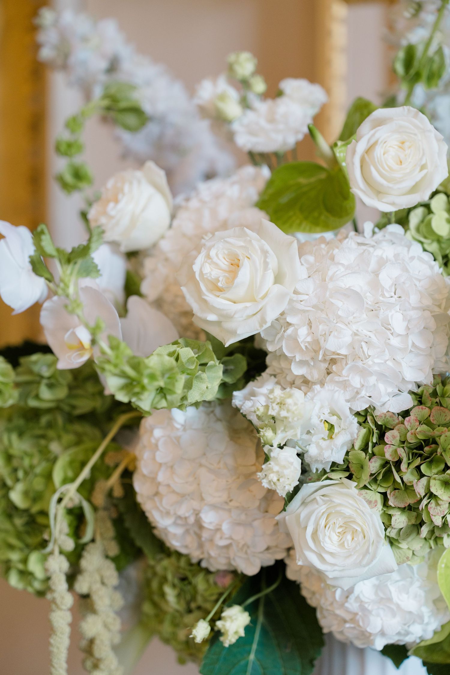 Elegant wedding floral arrangement featuring white roses, hydrangeas, and green accents in a lush bridal bouquet.