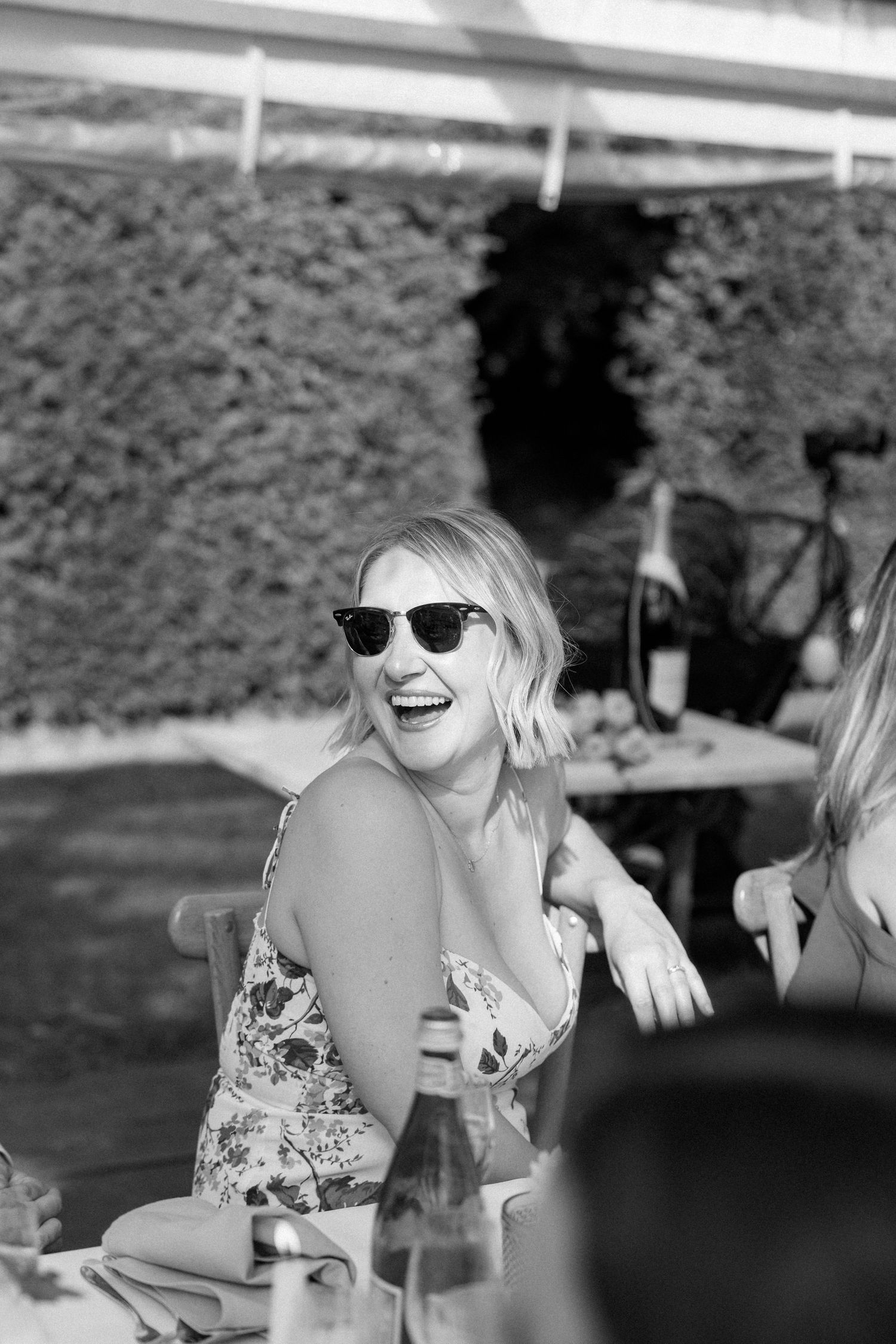 Black and white candid shots of guests laughing during a celebration.