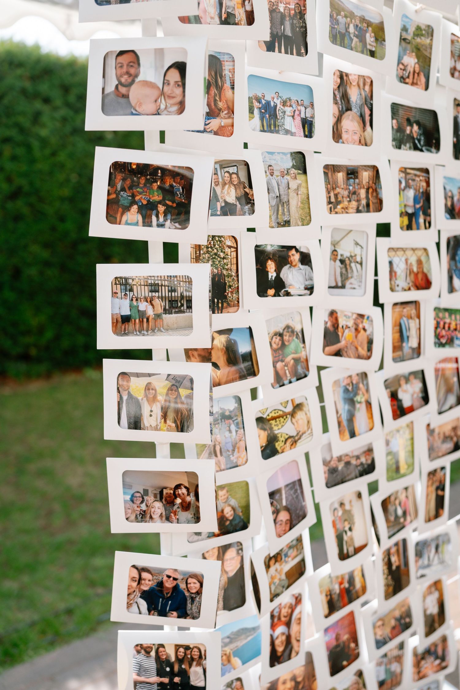 Photo display wall with multiple polaroid-style pictures arranged in a creative pattern.