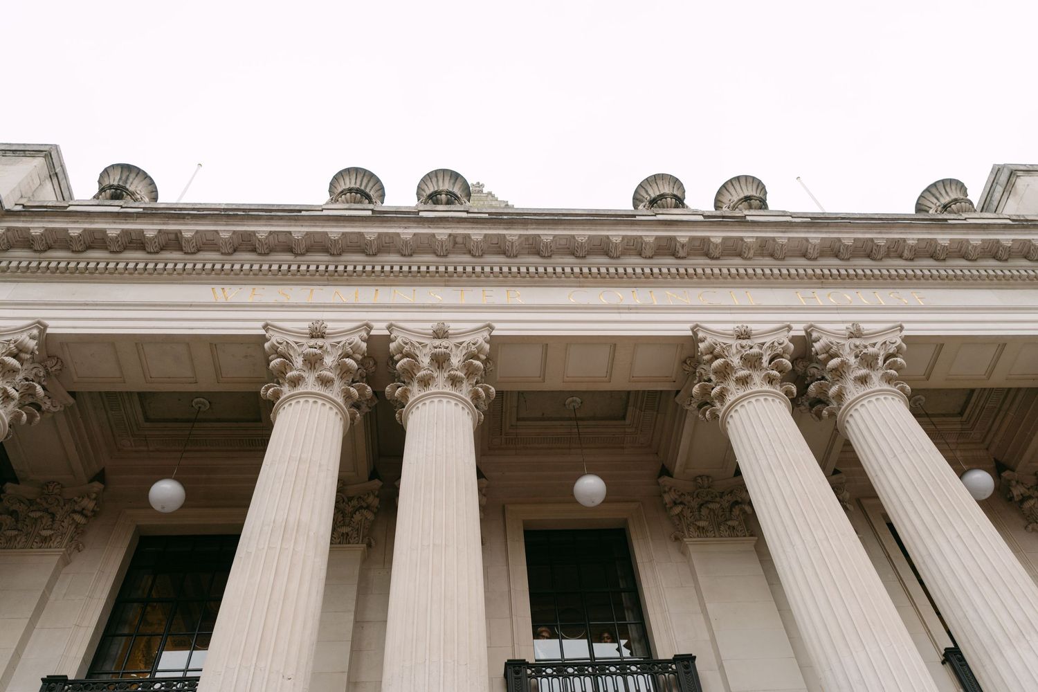 Exterior view of a grand classical building with white stone columns and ornate architectural details.