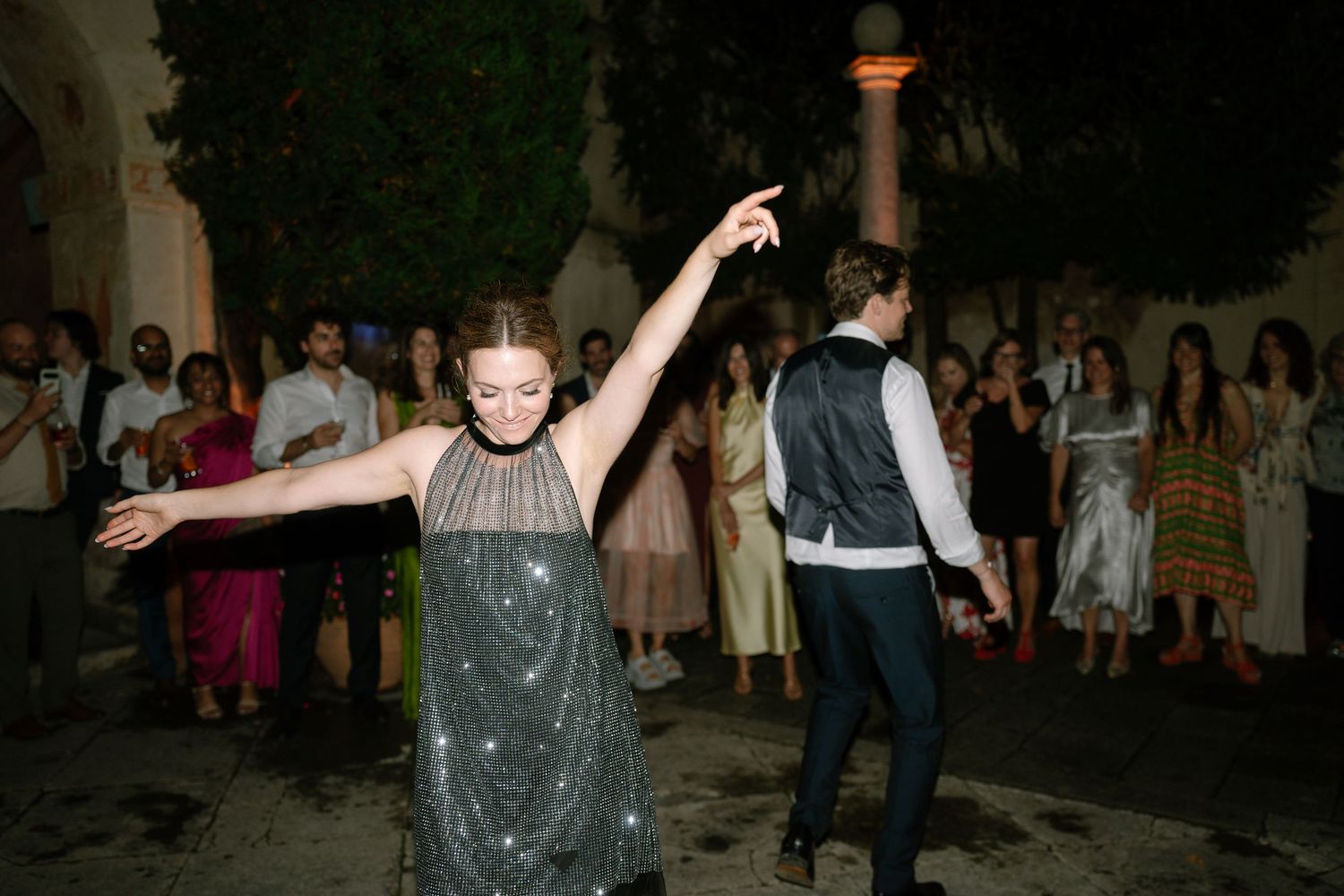 People dancing and celebrating at a lively party in a dimly lit venue.