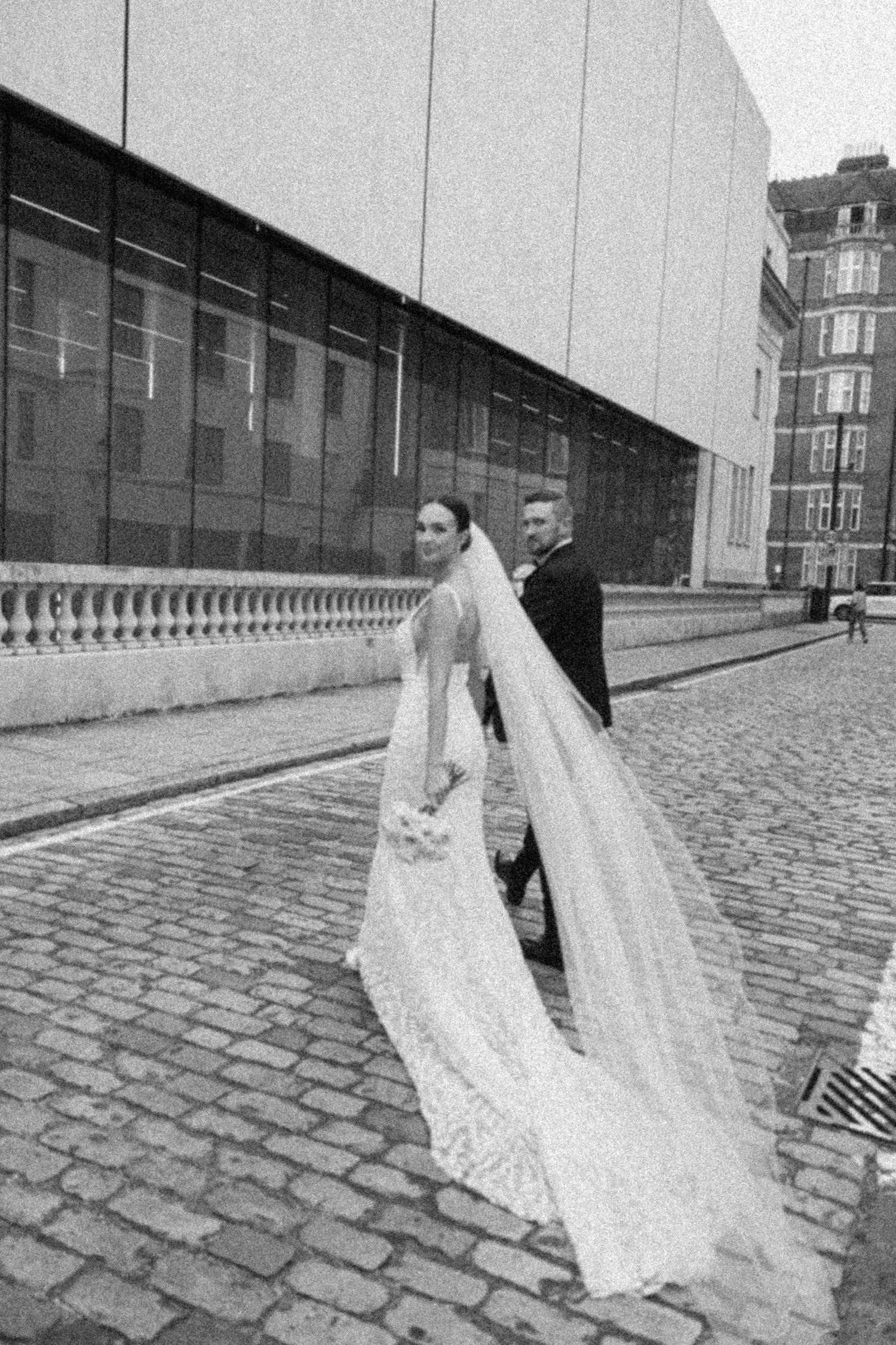 Black and white wedding photos showcasing modern architecture and cobblestone textures.