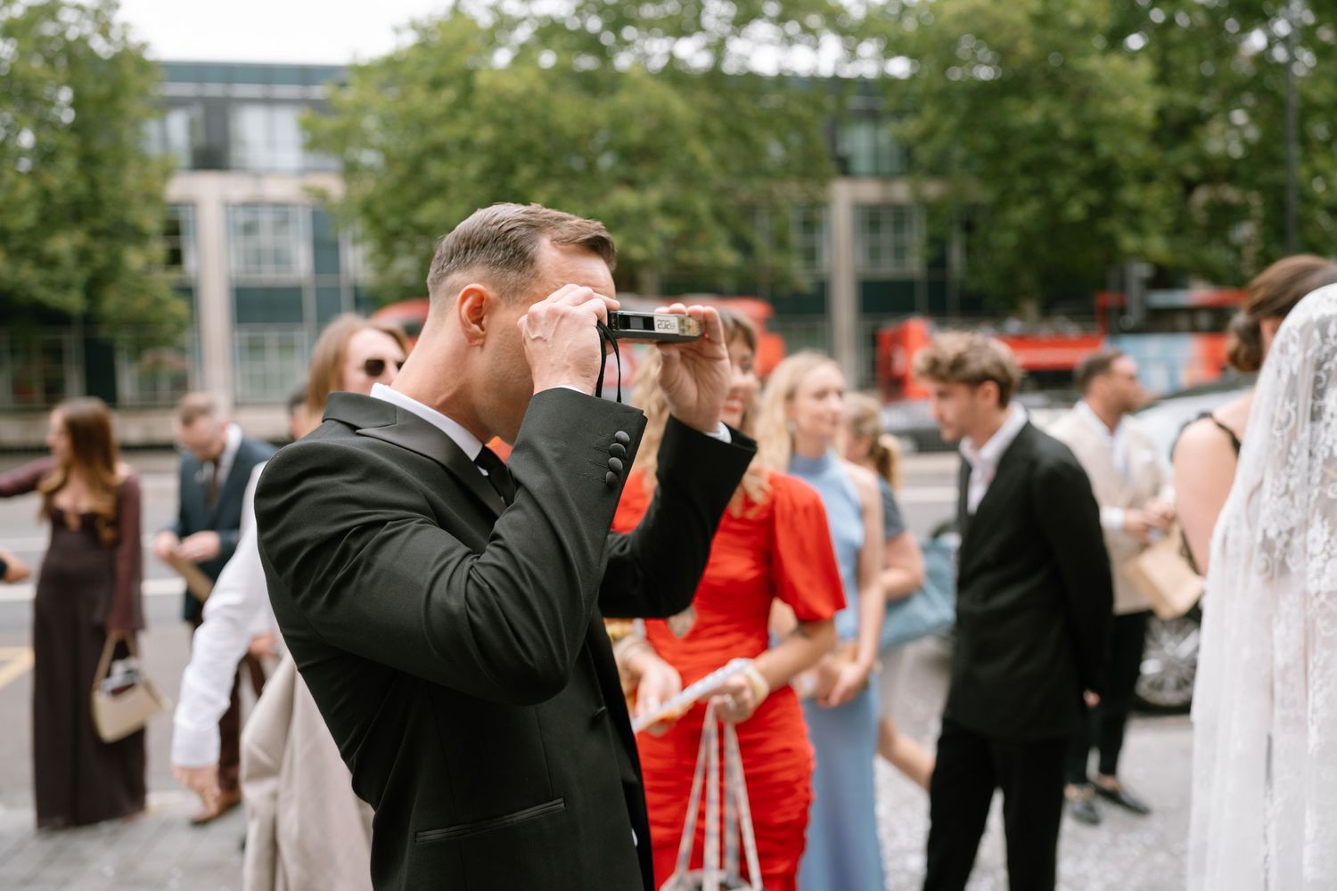 A guest captures photos during an outdoor wedding celebration.