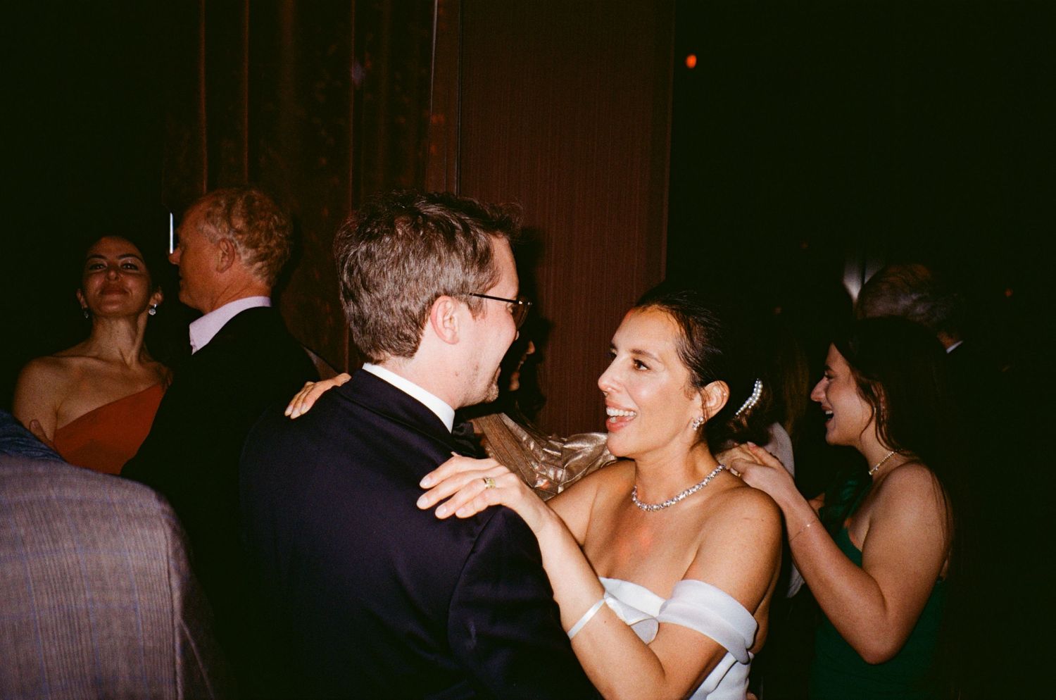 A couple shares a romantic dance moment at their wedding reception in formal attire.
