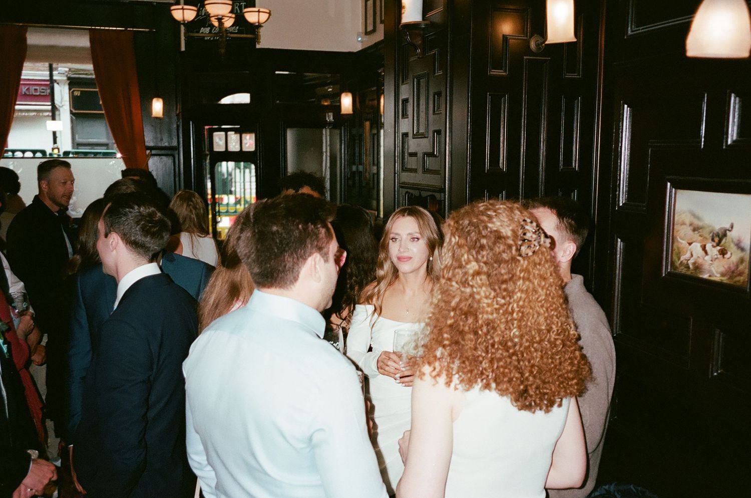 People gathered at a dimly lit bar or restaurant venue with warm lighting and decorative elements.