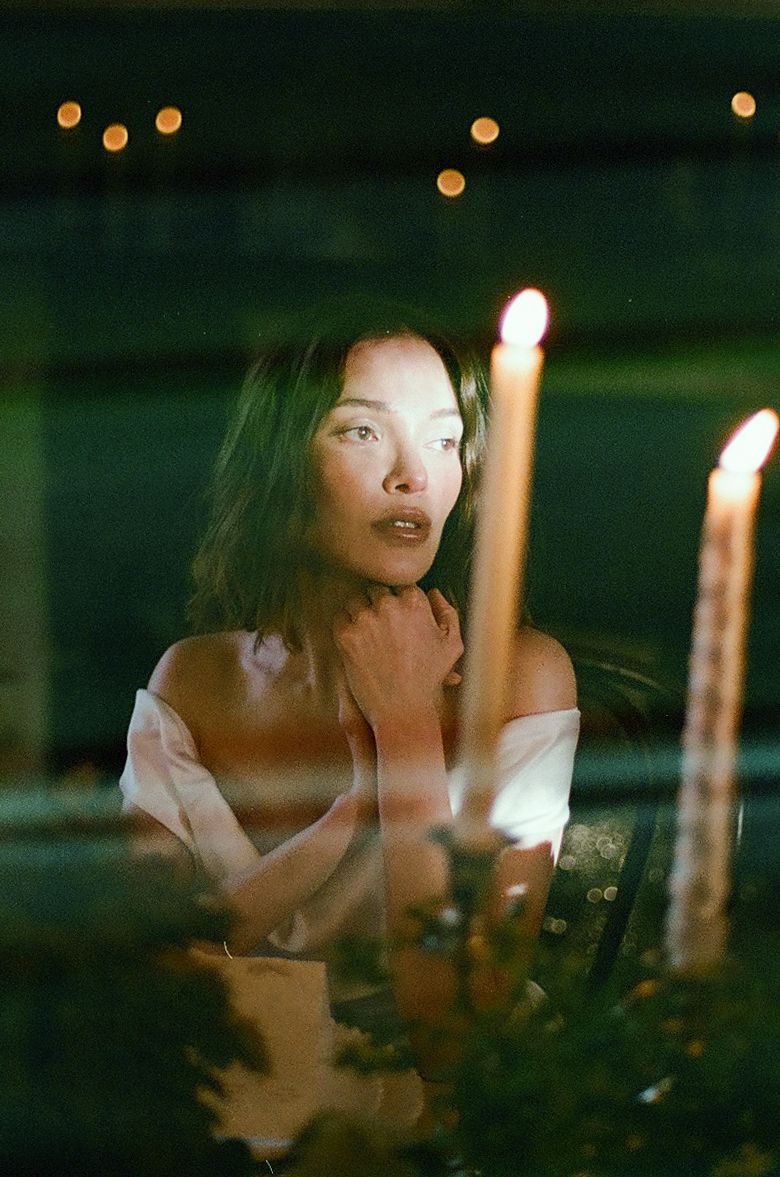 A sequence of candlelit photos shows someone blowing out birthday candles in a dark room.