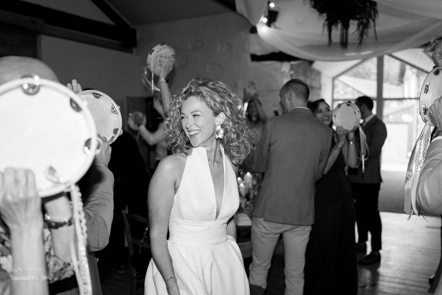 Wedding reception guests dancing in a dimly lit indoor venue.