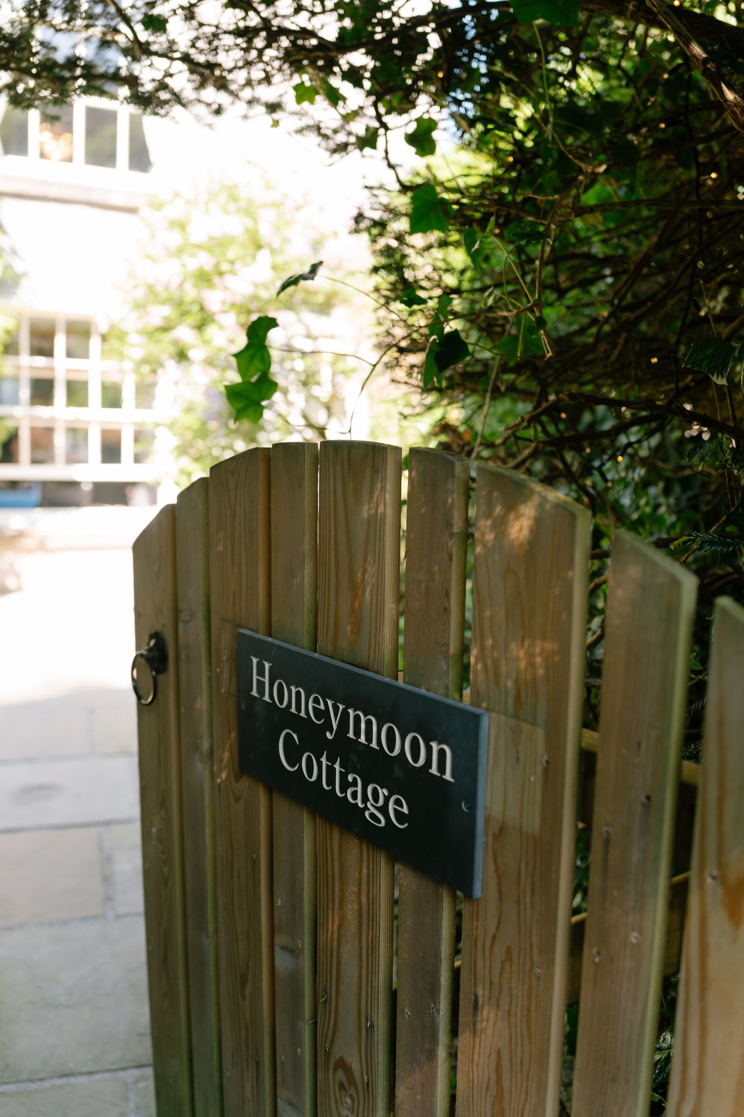 Wooden fence with cottage and honeymoon signs mounted on it.