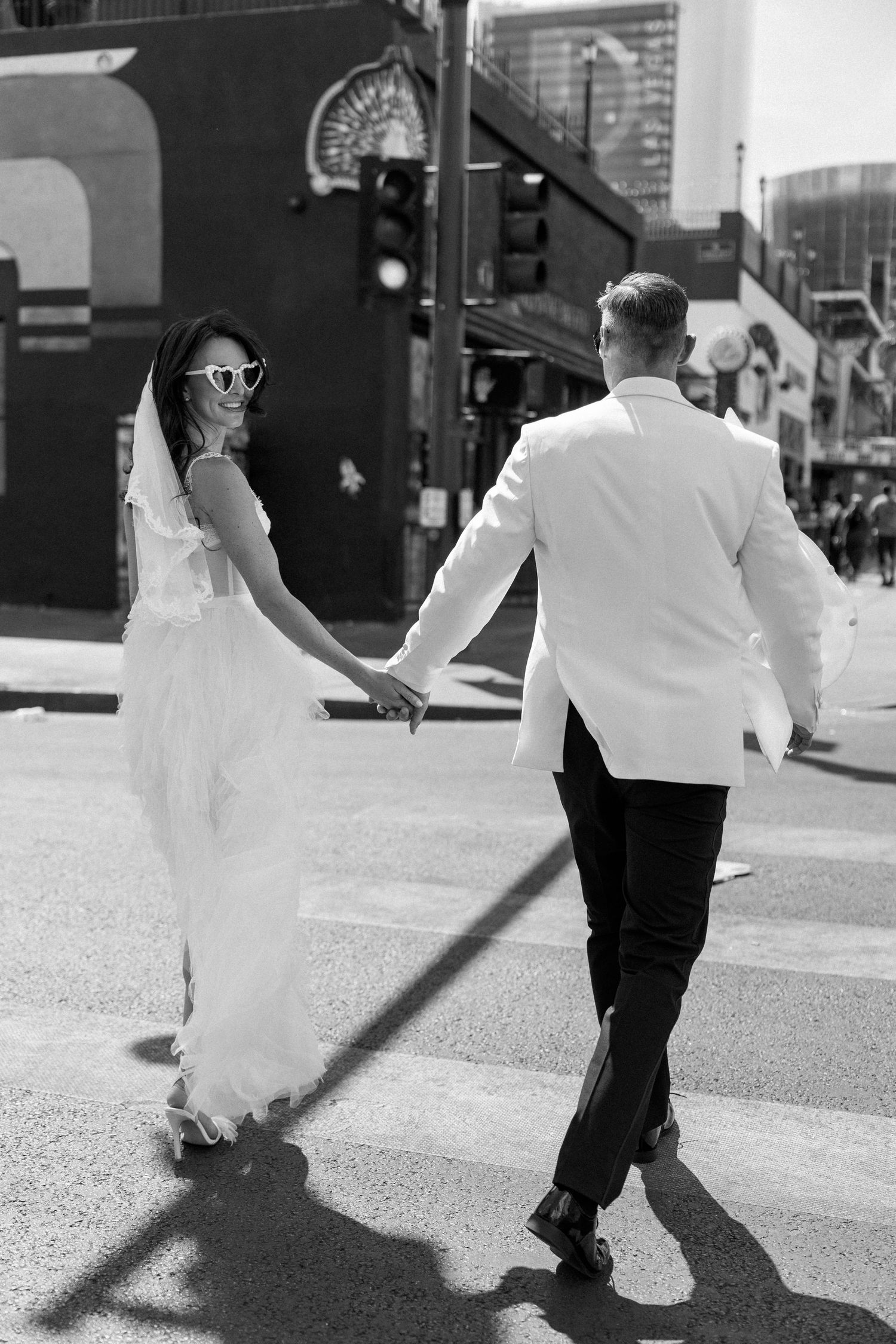 Dancing silhouettes on a sunny urban sidewalk with white and black contrasting outfits.