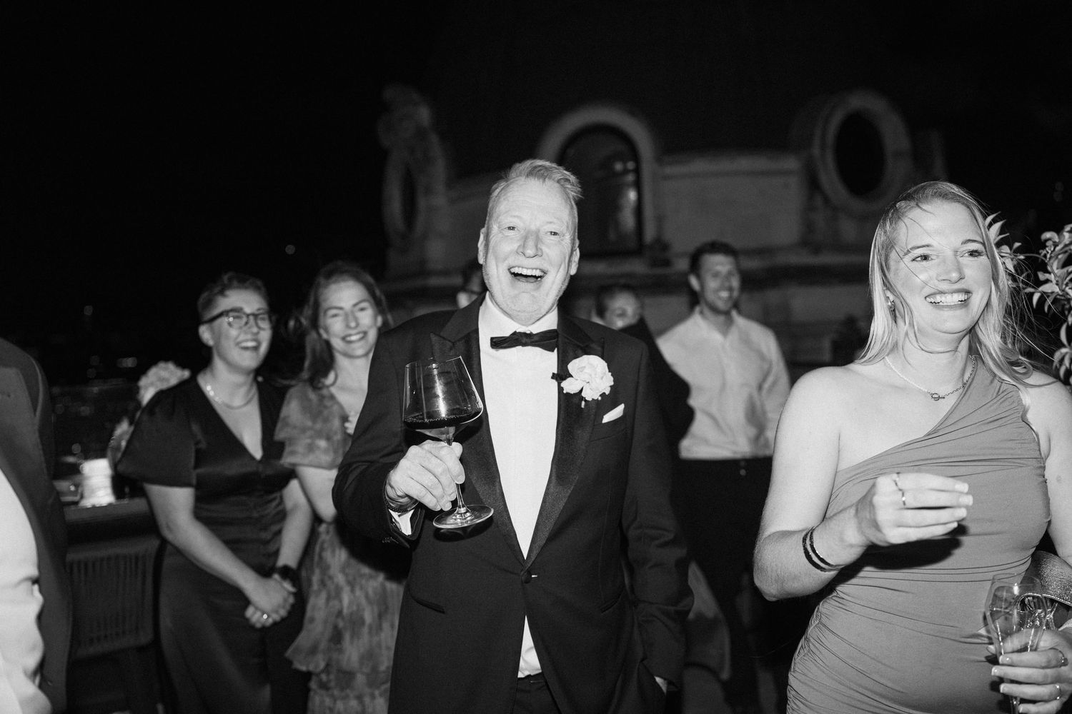 Wedding guests laughing and celebrating at a reception.